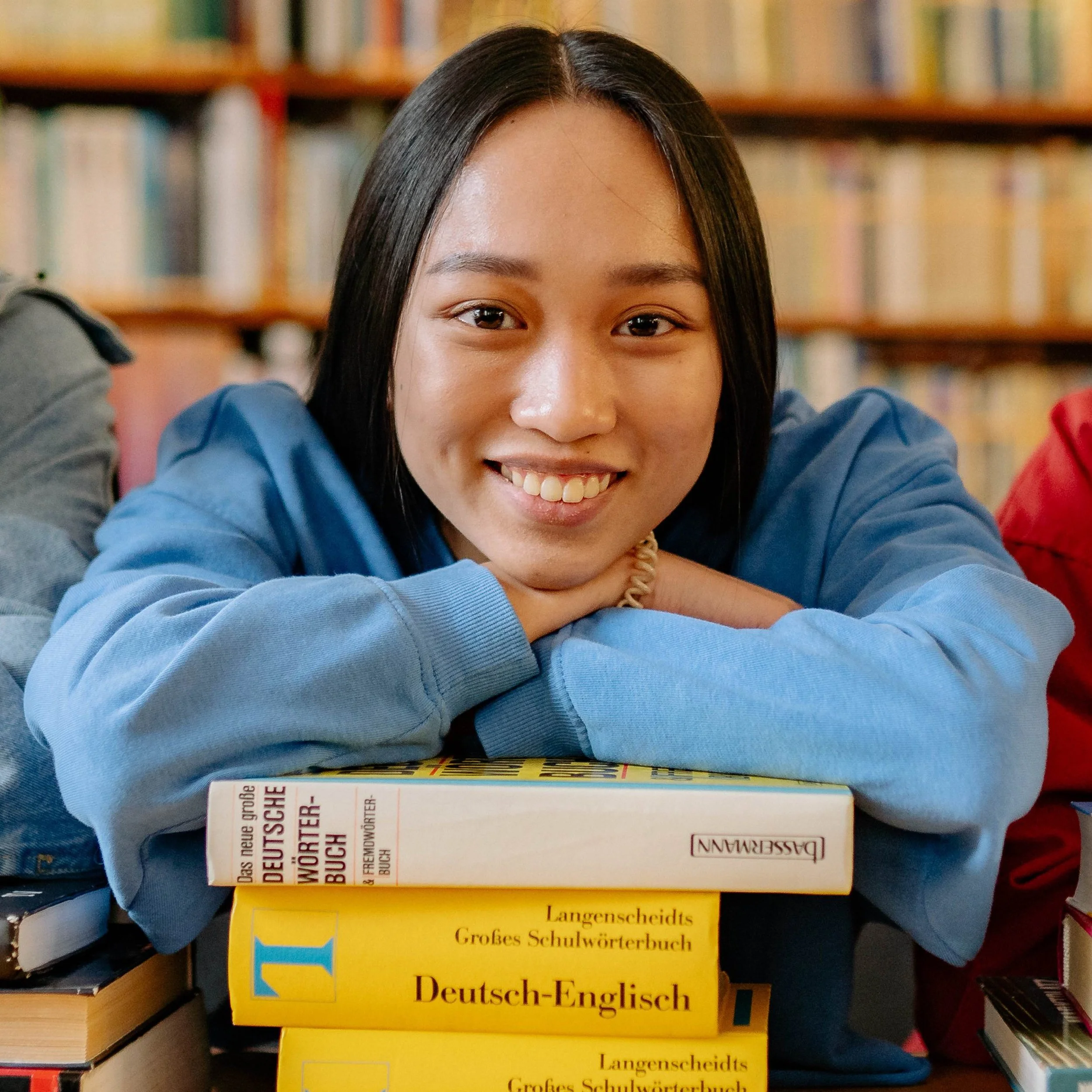 Junge Frau lernt Deutsch und stützt sich auf Deutsch Wörterbüchern ab