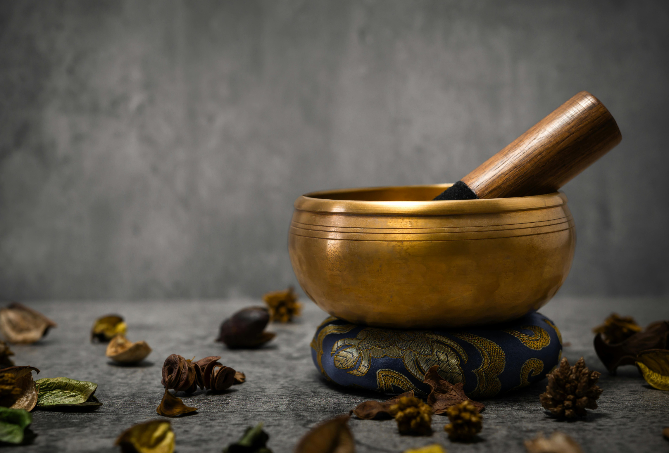 Tibetan singing bowl with a wooden mallet and petals