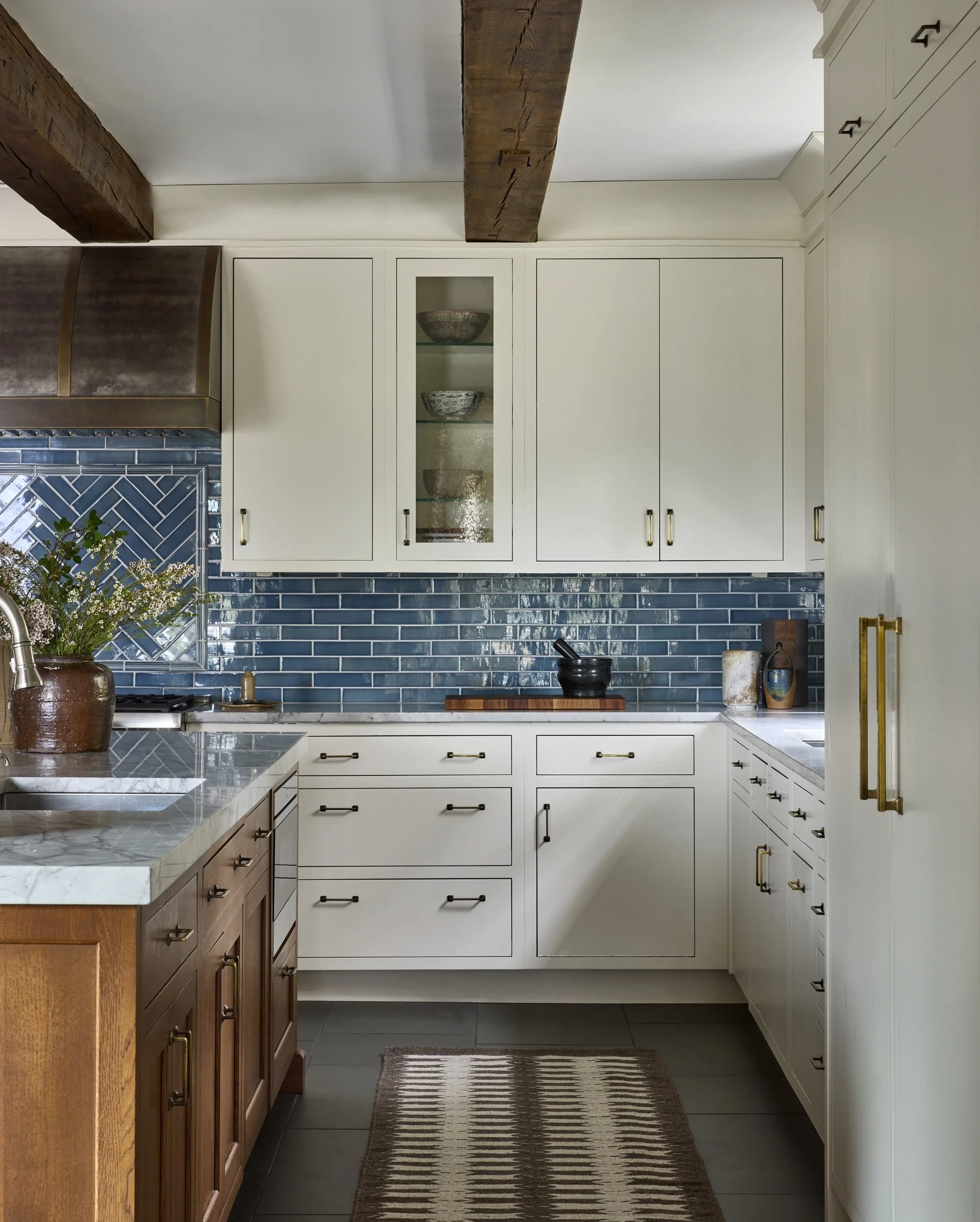 White kitchen cabinets with a blue tile backsplash