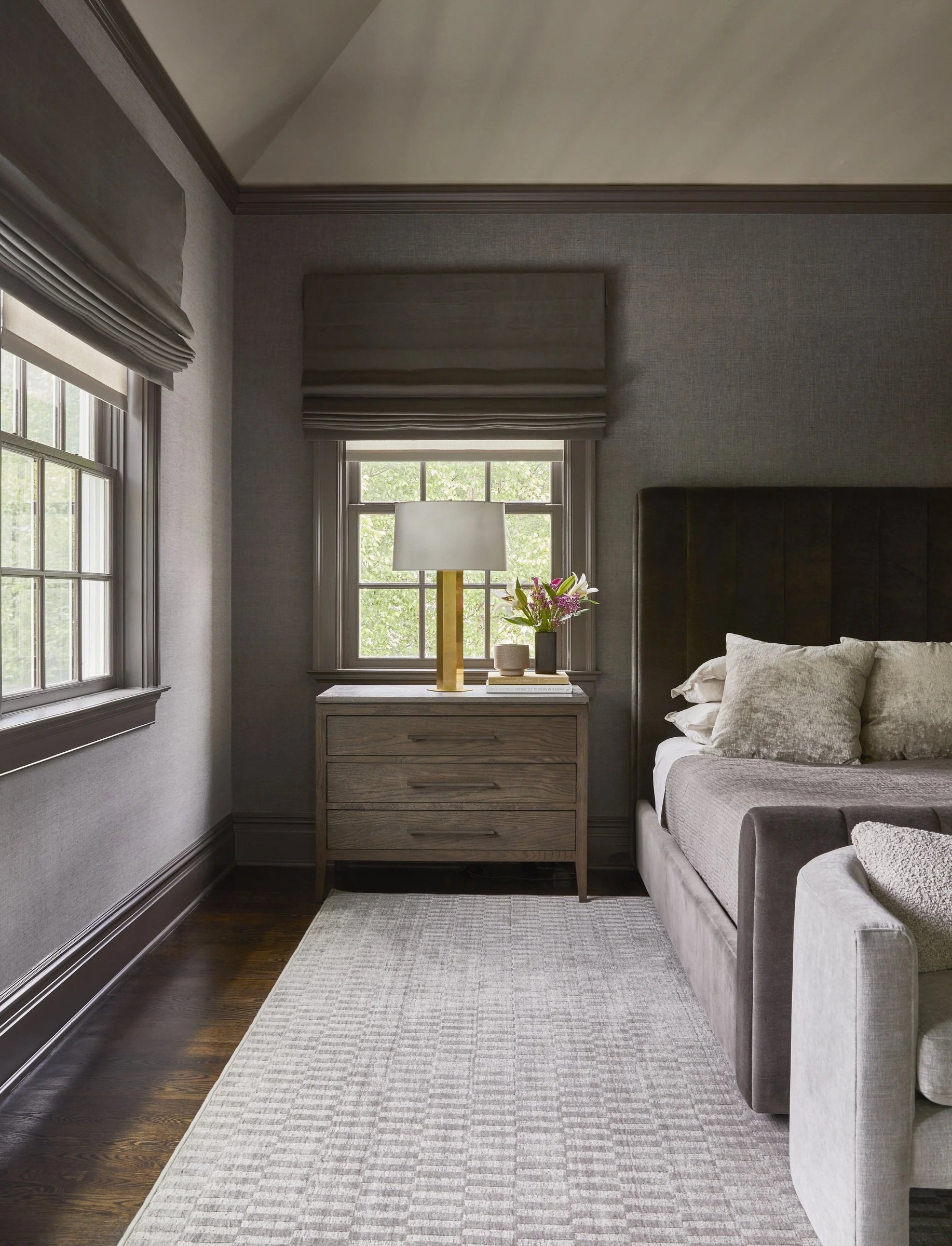 Neutral bedroom with a patterned curtain and upholstered chaise