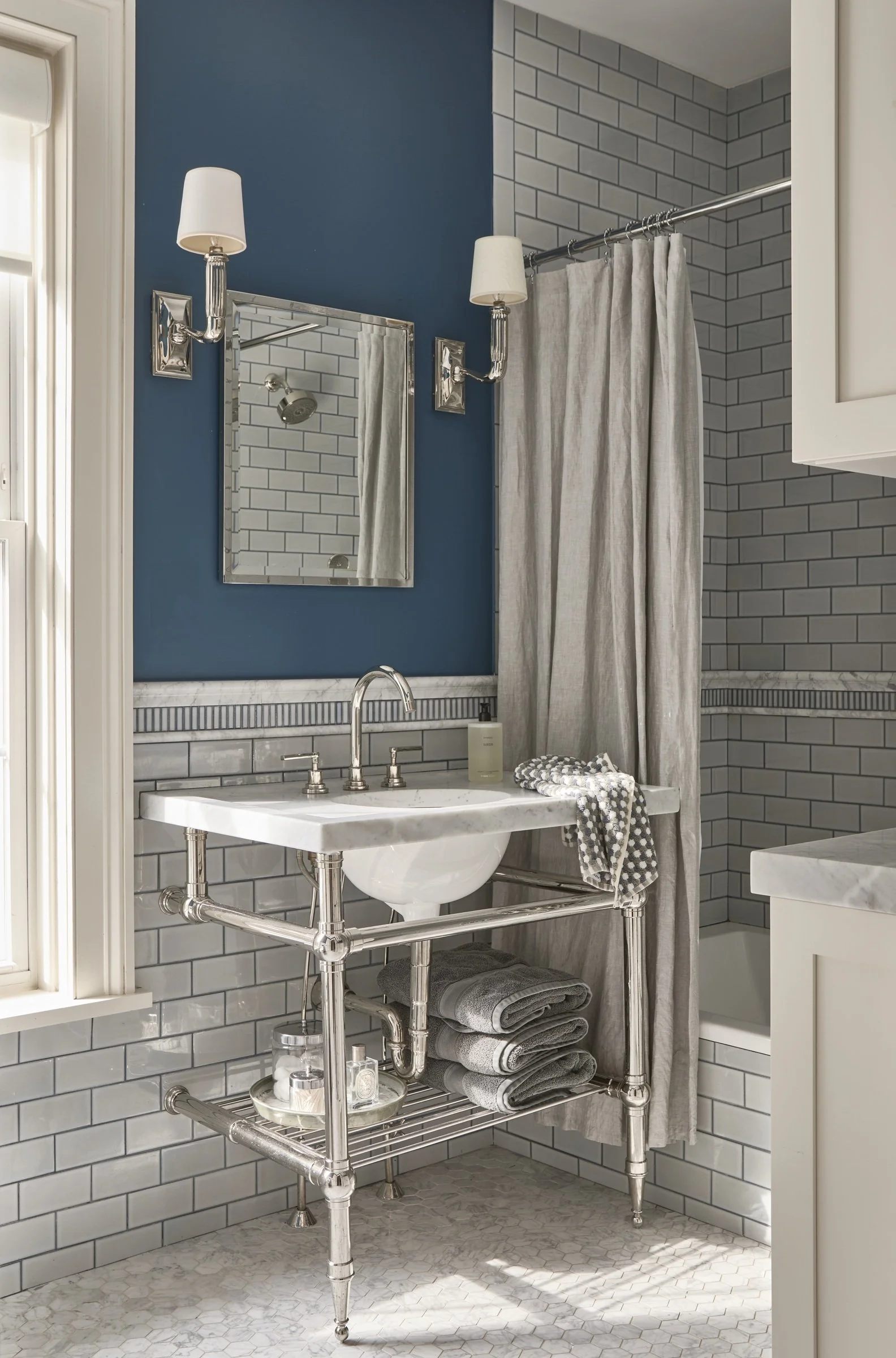 Bathroom with blue walls, a freestanding bathtub and patterned tile