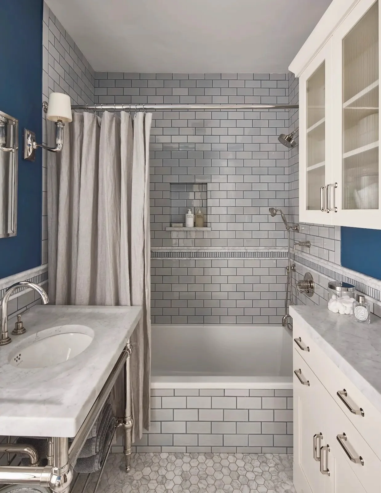 Bathroom with white cabinets, patterned tile and a shower curtain