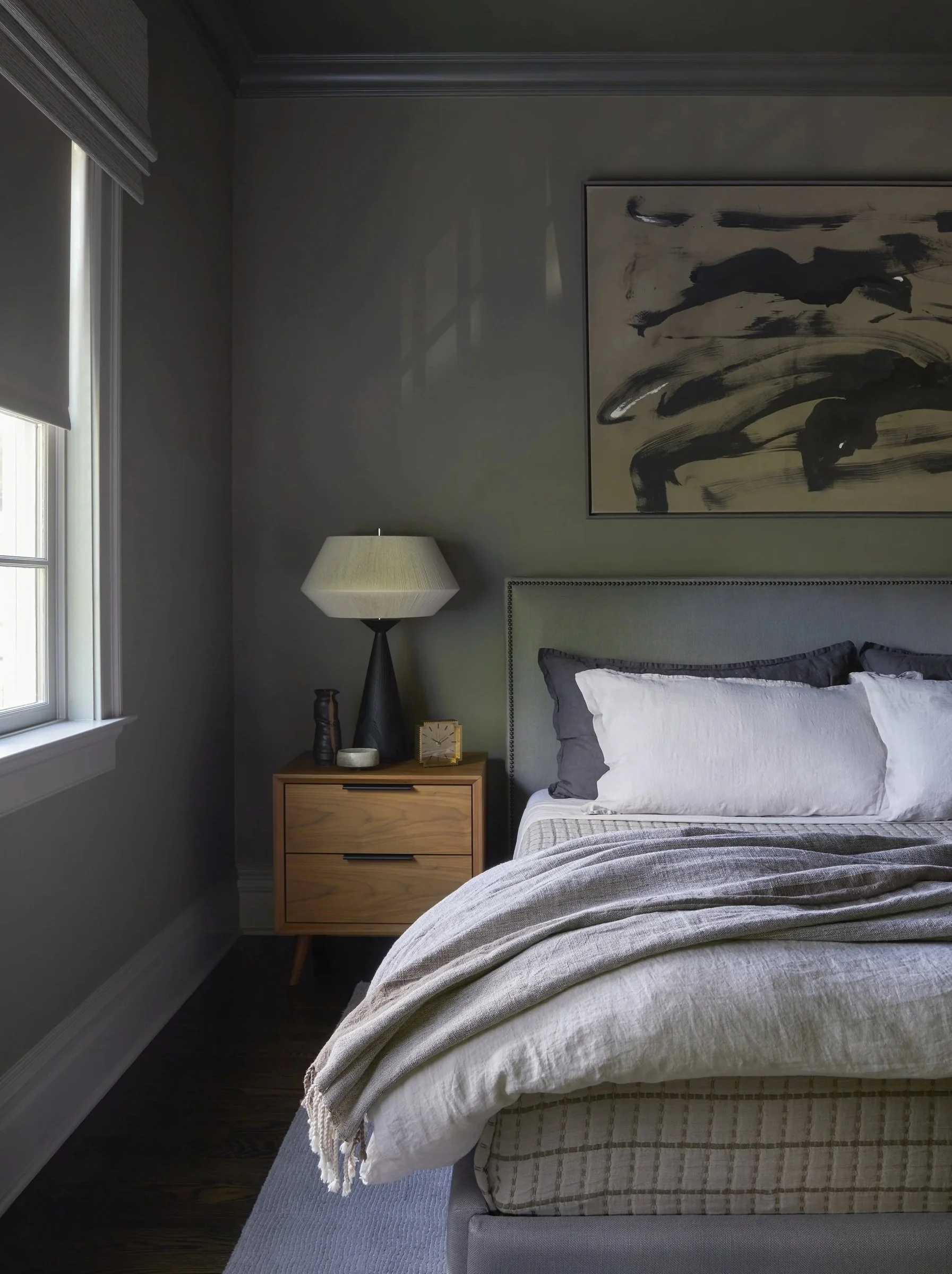 Bedroom with gray bedding and a pendant light
