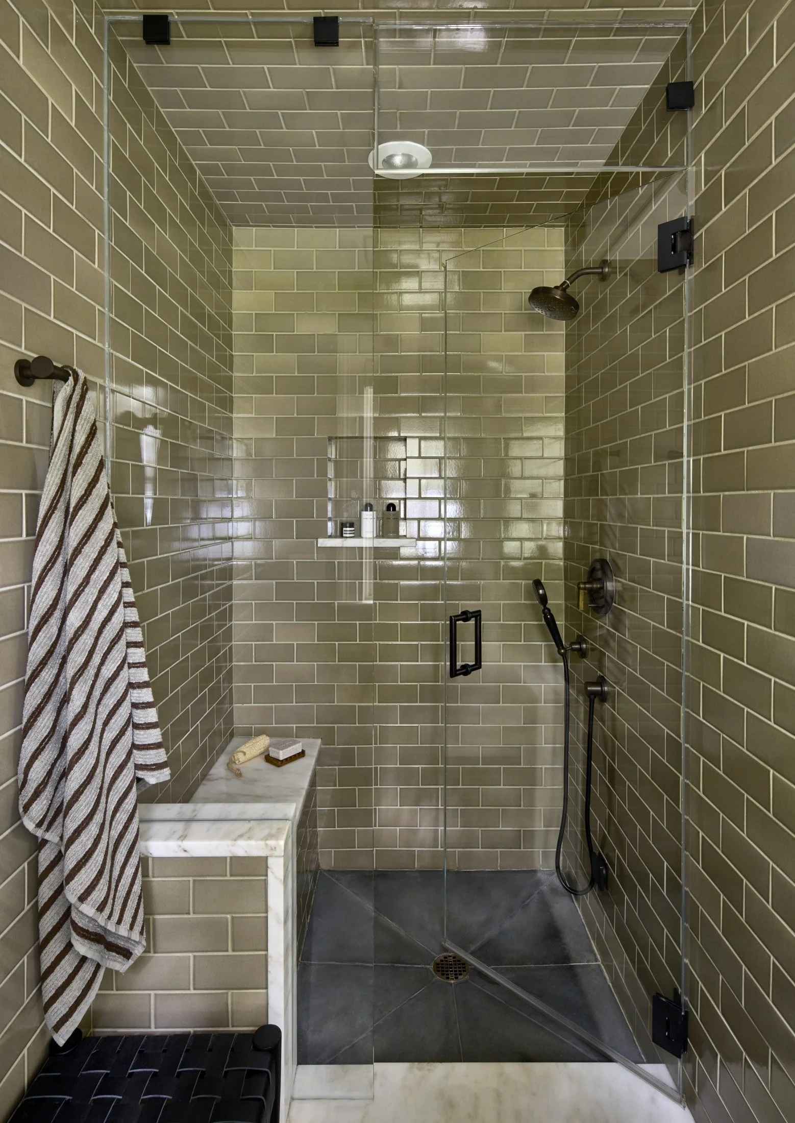 Tiled shower with a built-in bench and a dark shower head