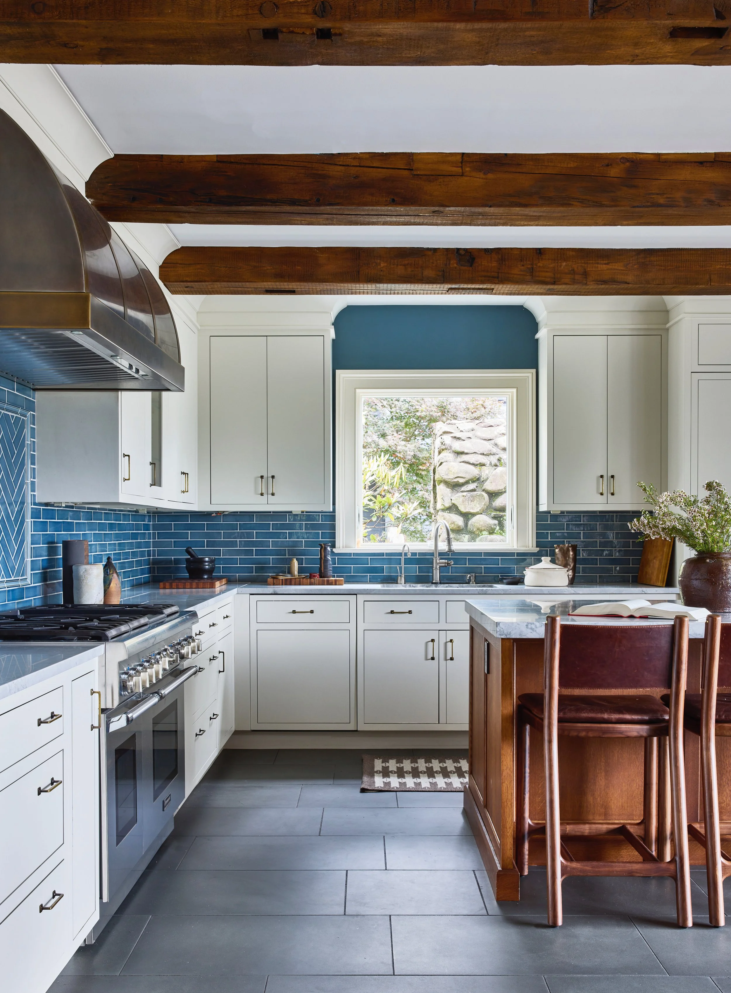 Farmhouse kitchen with blue trim, white cabinets and exposed wood beams
