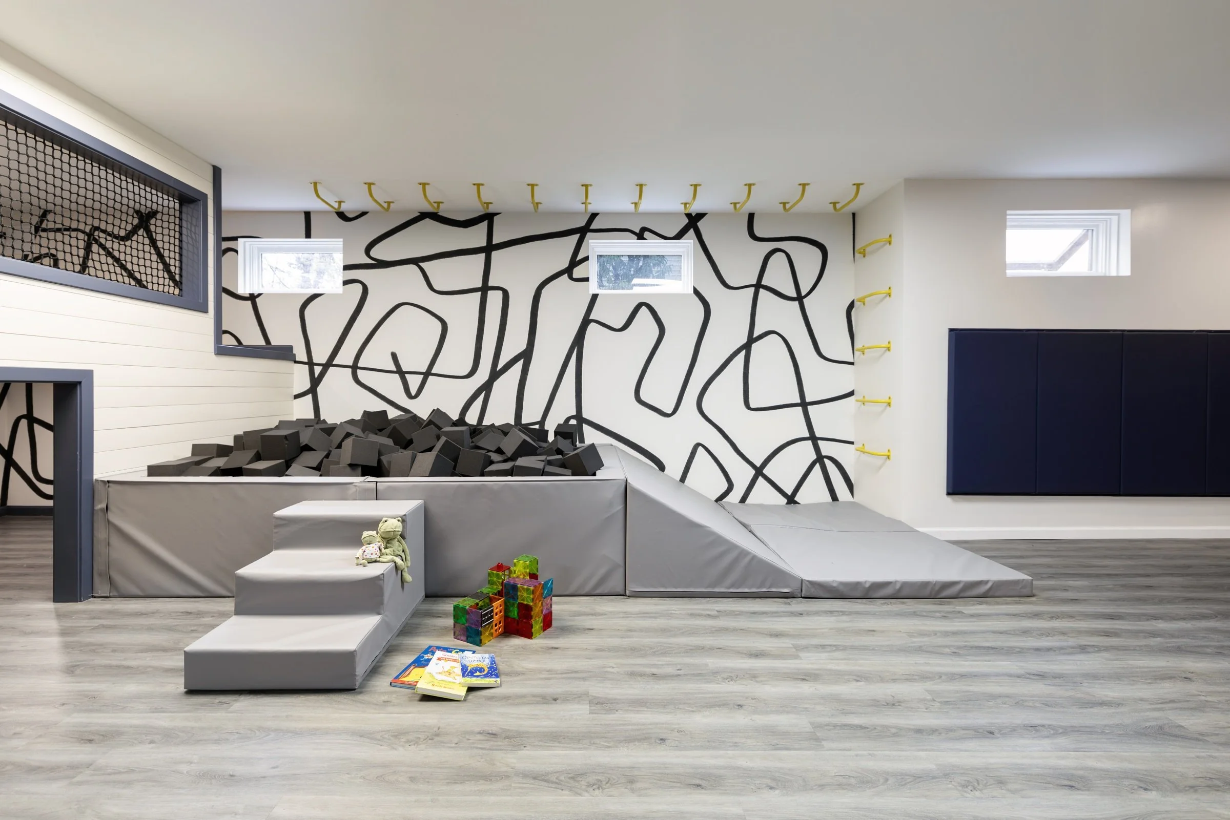 Playroom with an abstract black-and-white wall mural and modular seating