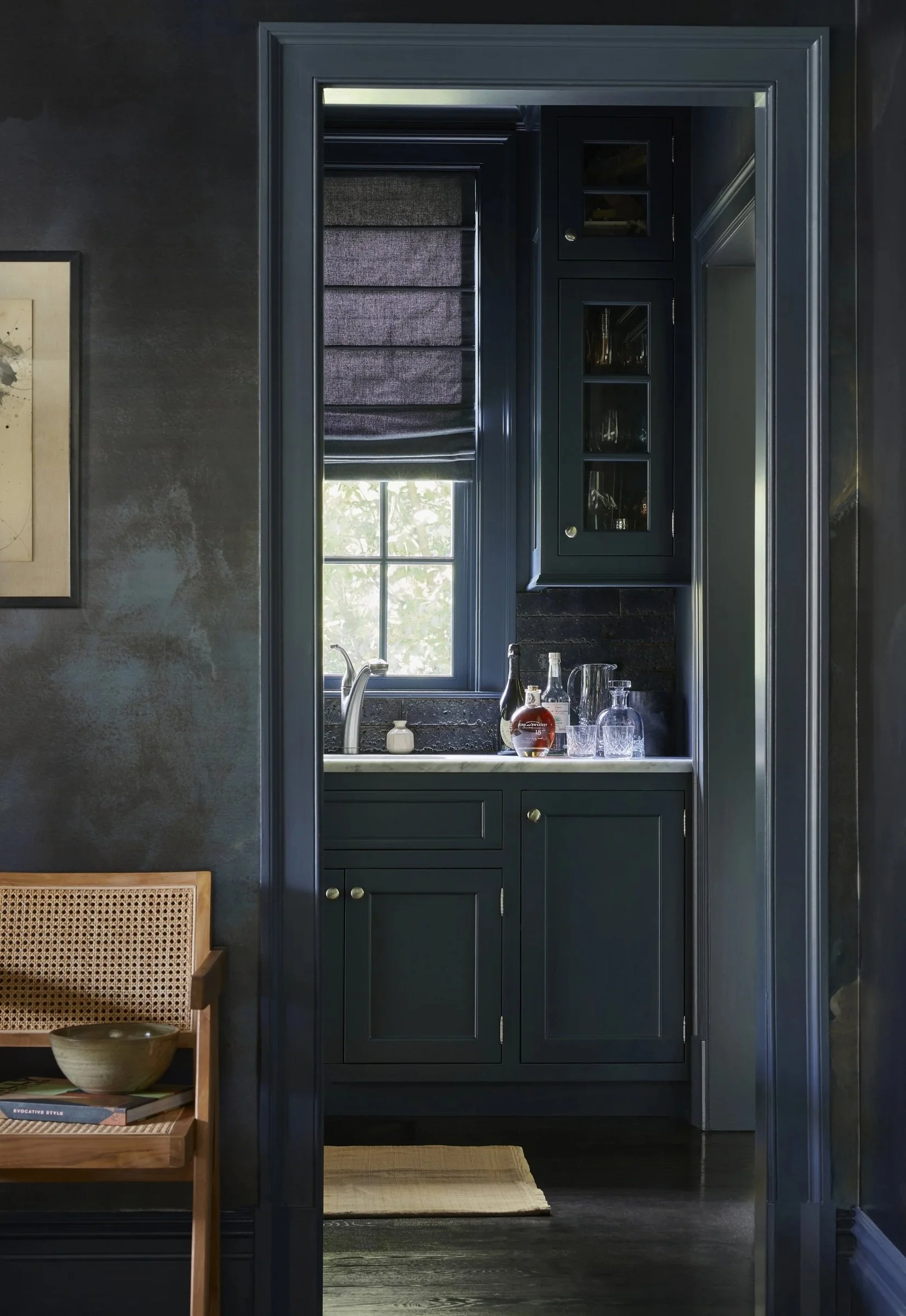 Dark blue pantry with glass-front cabinets and a countertop