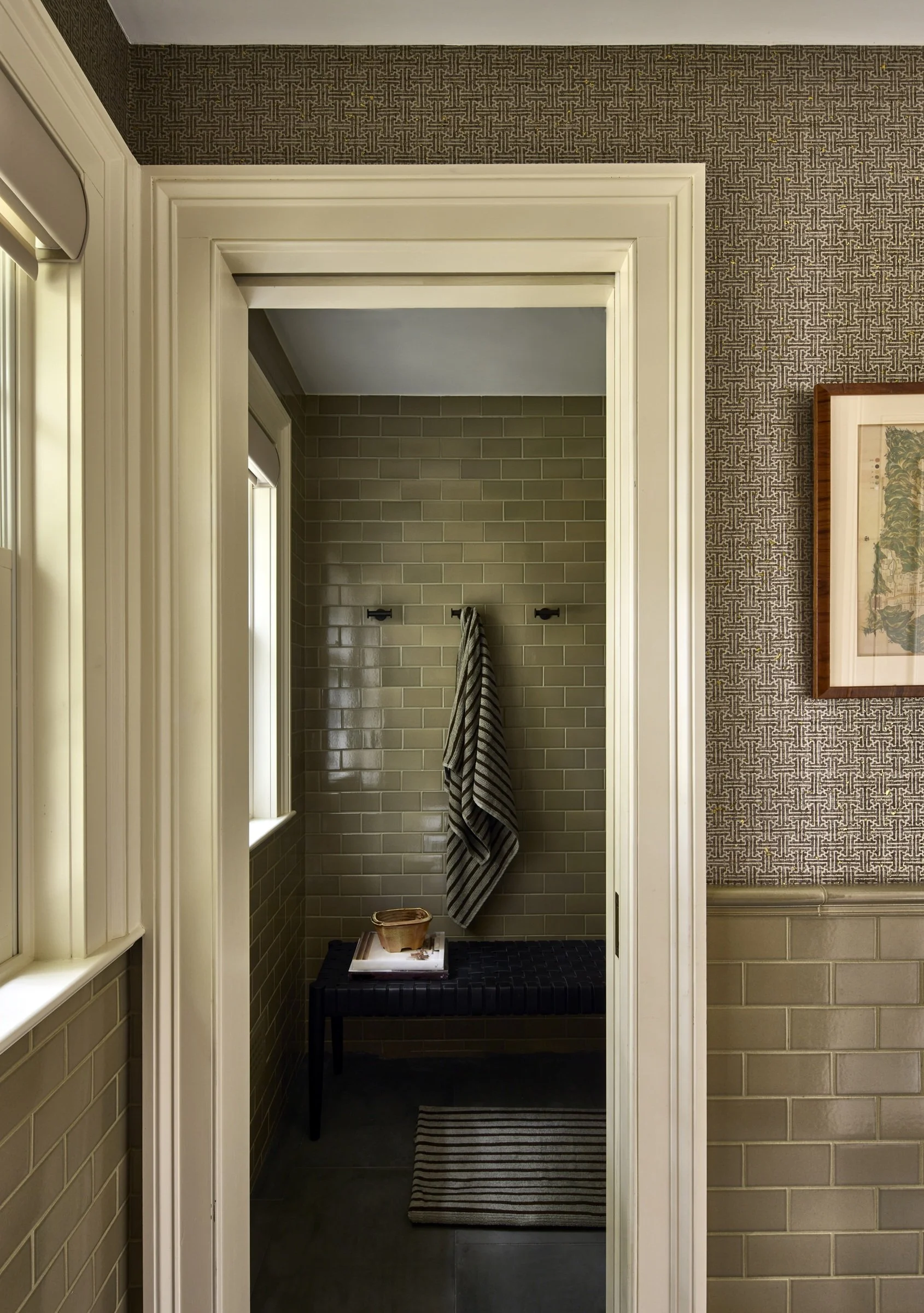 Hallway looking into a bathroom with a dark vanity