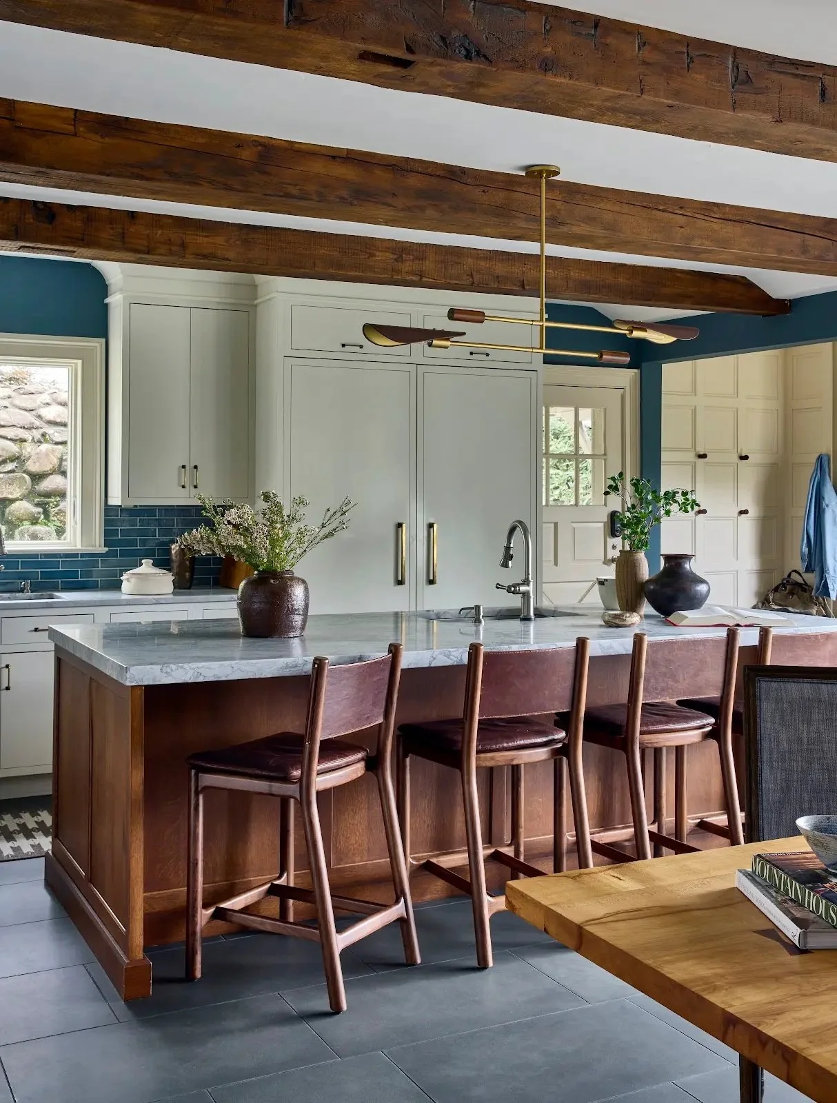 Kitchen island with wood stools beneath exposed ceiling beams