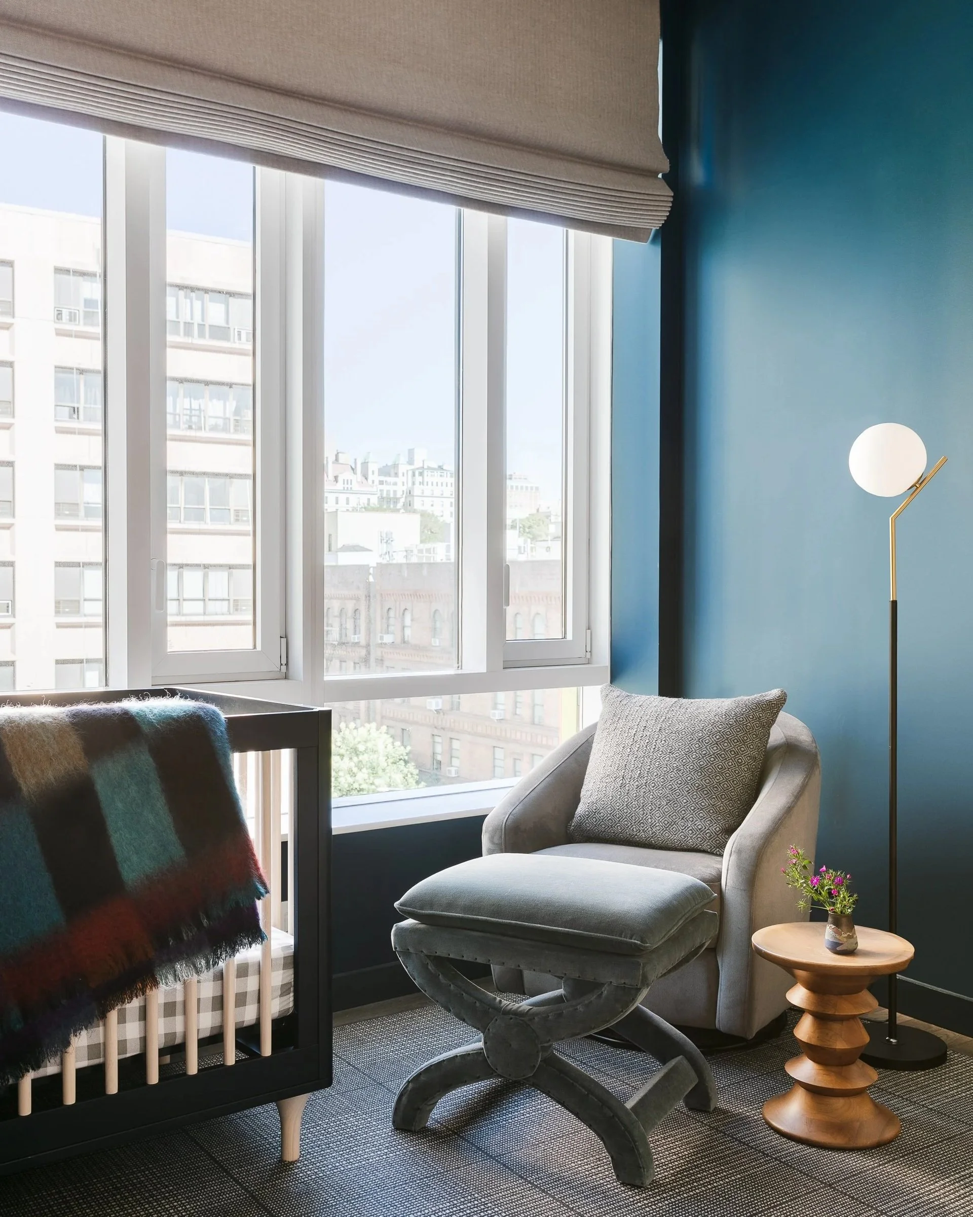 Sitting area with a gray armchair beside a window and blue wall