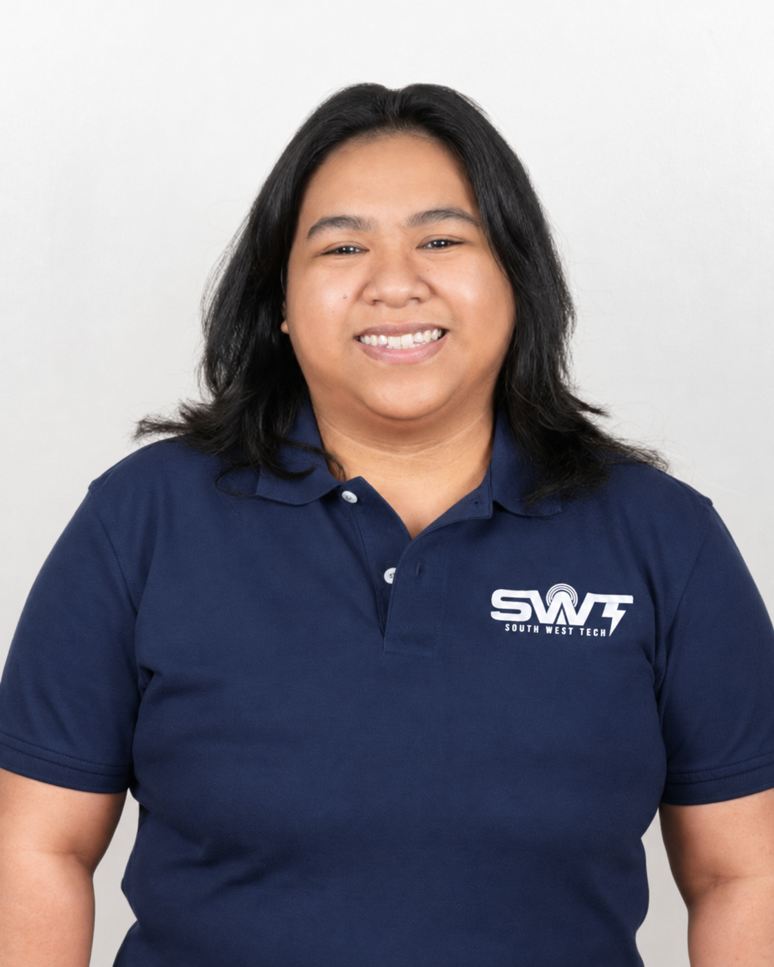 A woman smiling, wearing a navy blue polo shirt with the South West Tech logo, standing against a plain white background.