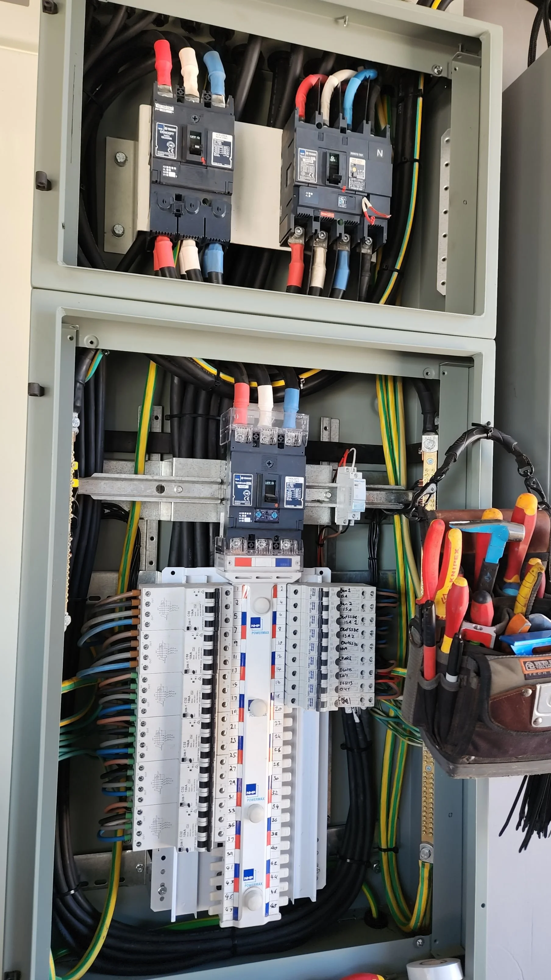 Electrical control panel with circuit breakers, wiring, and fuses.