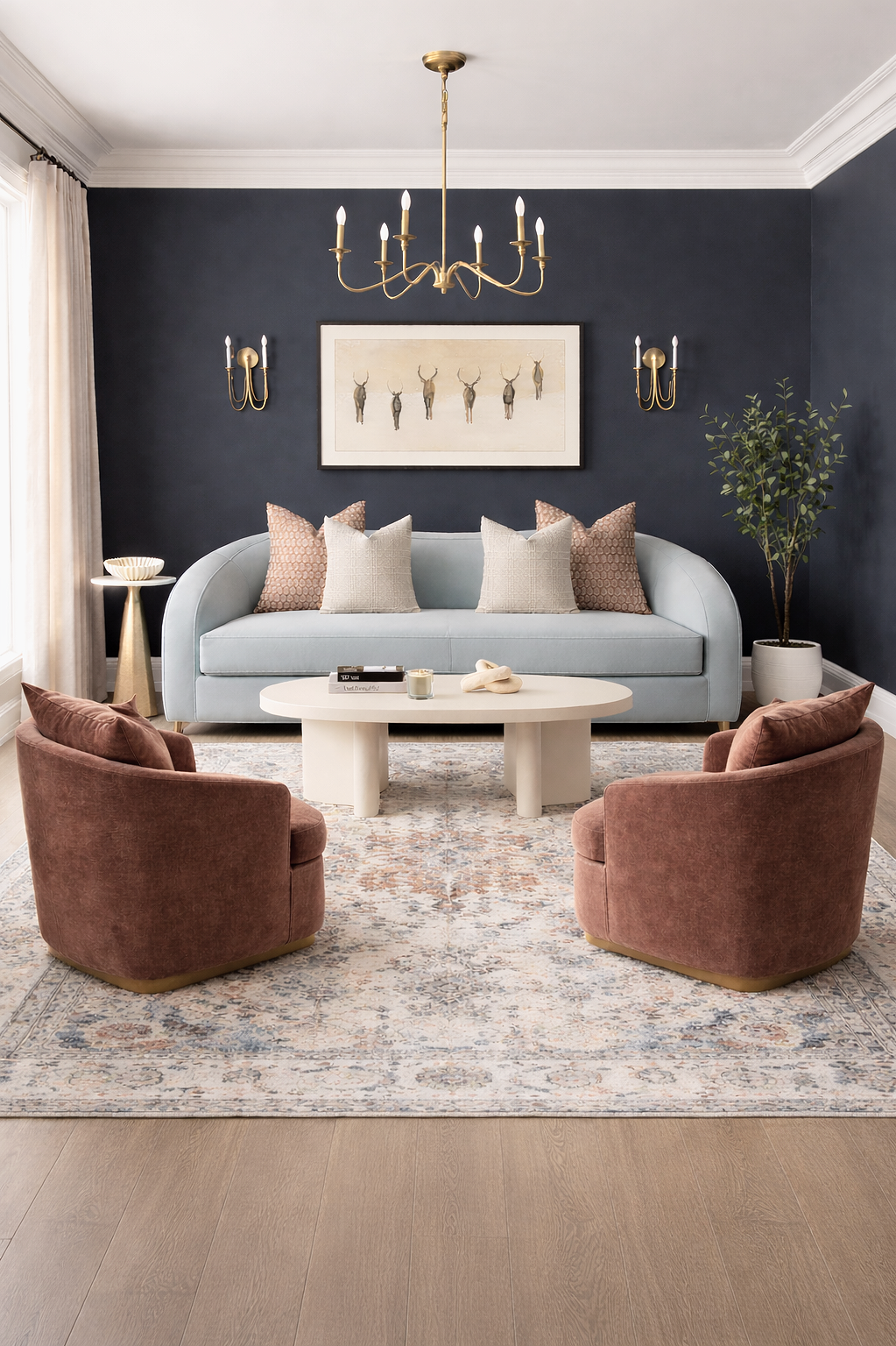 Modern+winter+living+room+with+muted+blue+sofa%2C+navy+accent+wall%2C+camel+velvet+chairs%2C+brass+chandelier%2C+and+creamy+neutral+decor.png