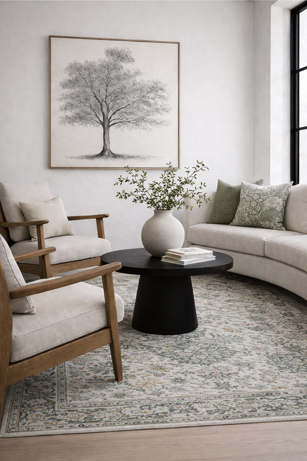Cozy+organic+modern+living+room+with+curved+sofa%2C+green+accent+pillows%2C+Loloi-style+patterned+rug%2C+black+pedestal+coffee+table%2C+and+large+ceramic+vase+with+greenery.png