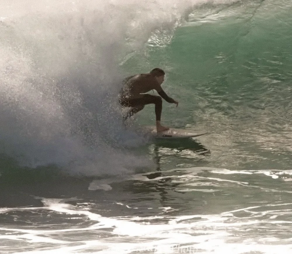 Person surfing on a wave in the ocean.
