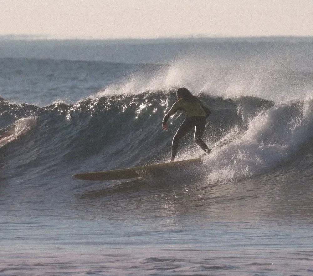 A person surfing on a wave in the ocean during daytime.