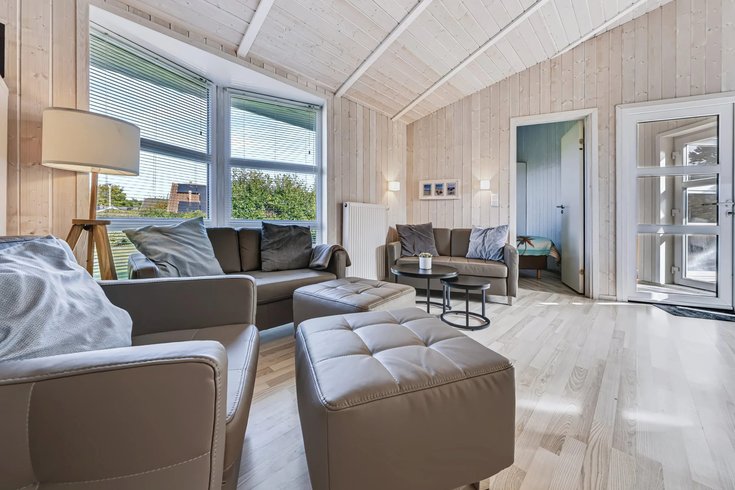 Wohnzimmer mit Balkonzugang
Heller Wohnbereich in The Lazy Möwe mit Ledersofas, großen Fenstern und Zugang zur Terrasse