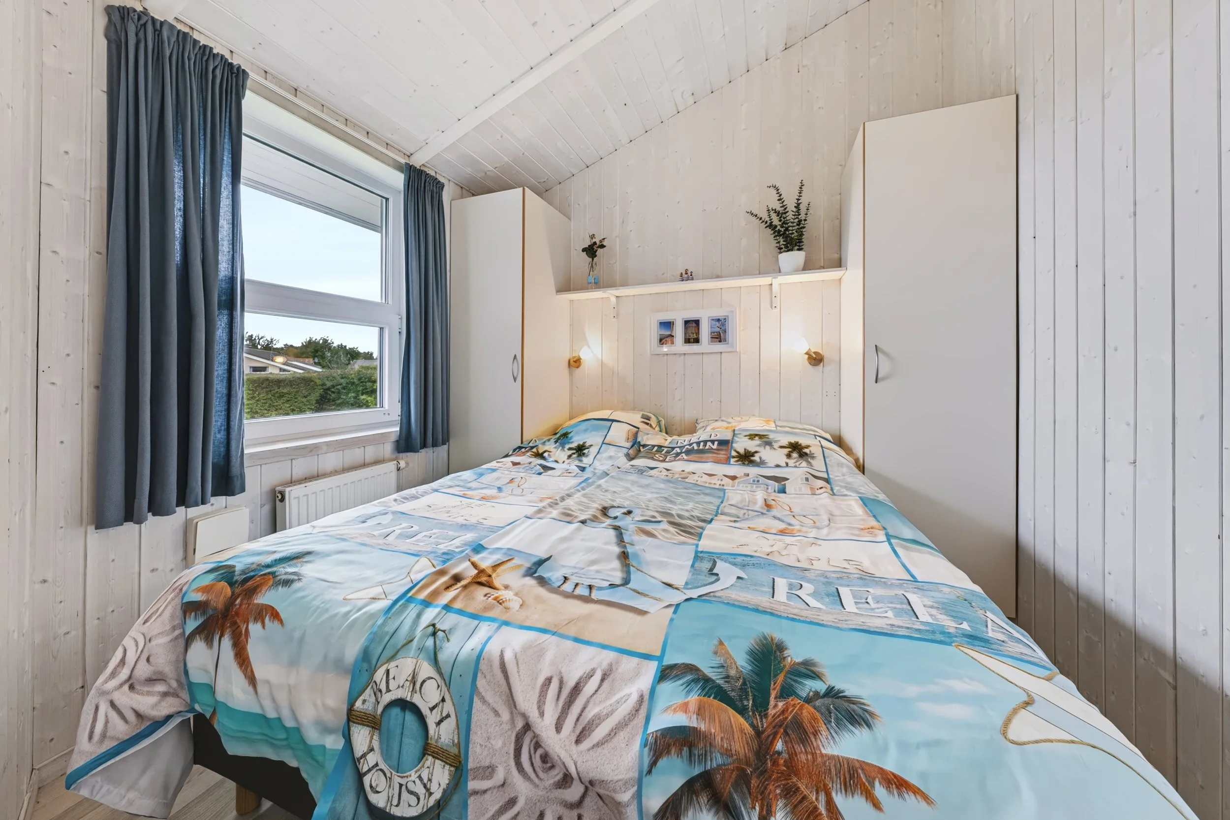 Schlafzimmer mit maritimer Bettwäsche
Gemütliches Schlafzimmer in The Lazy Möwe mit maritimer Bettwäsche und blauen Vorhängen