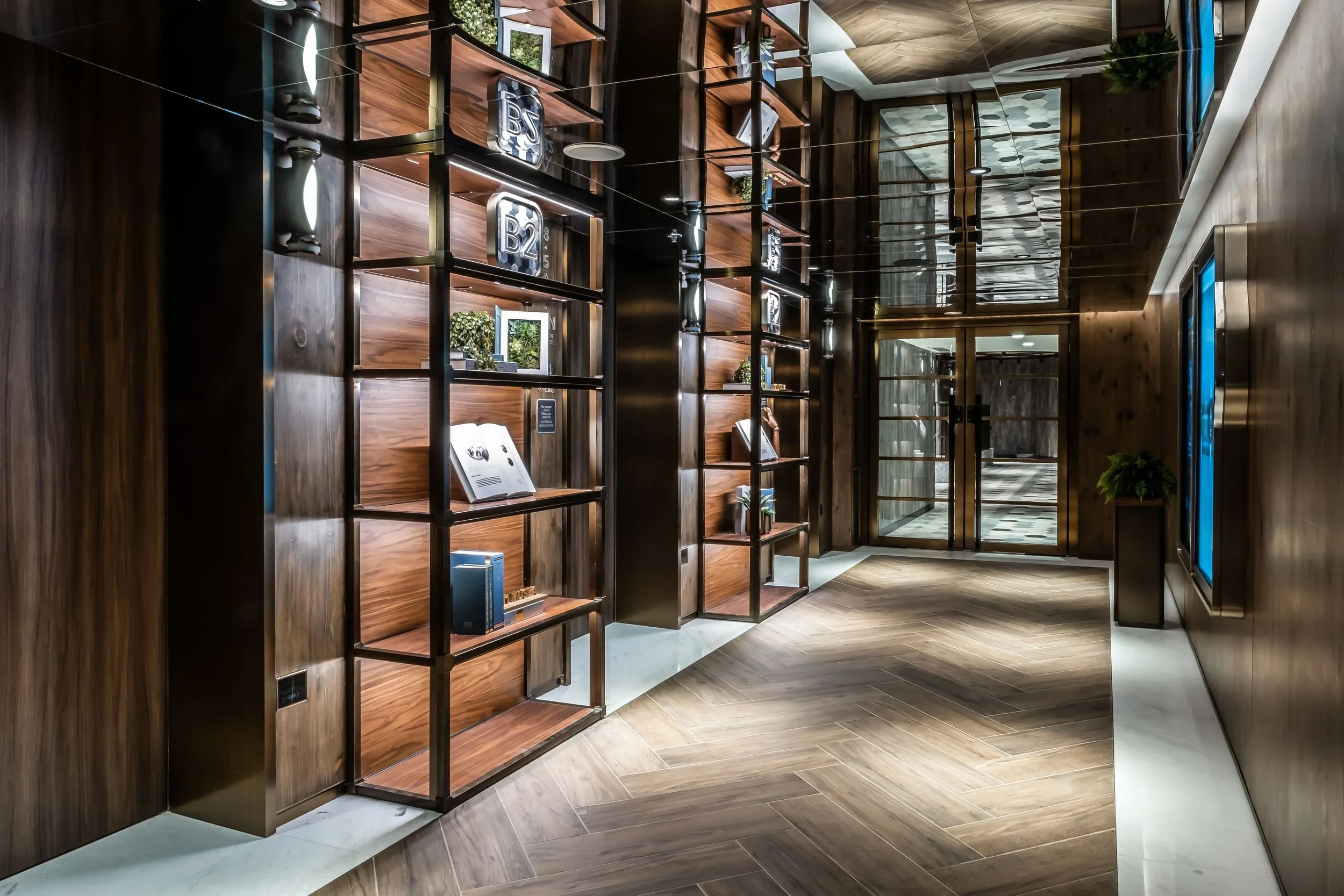 Modern interior with wooden shelves, decorative items, and glass doors. Wooden flooring and walls with sleek lighting.