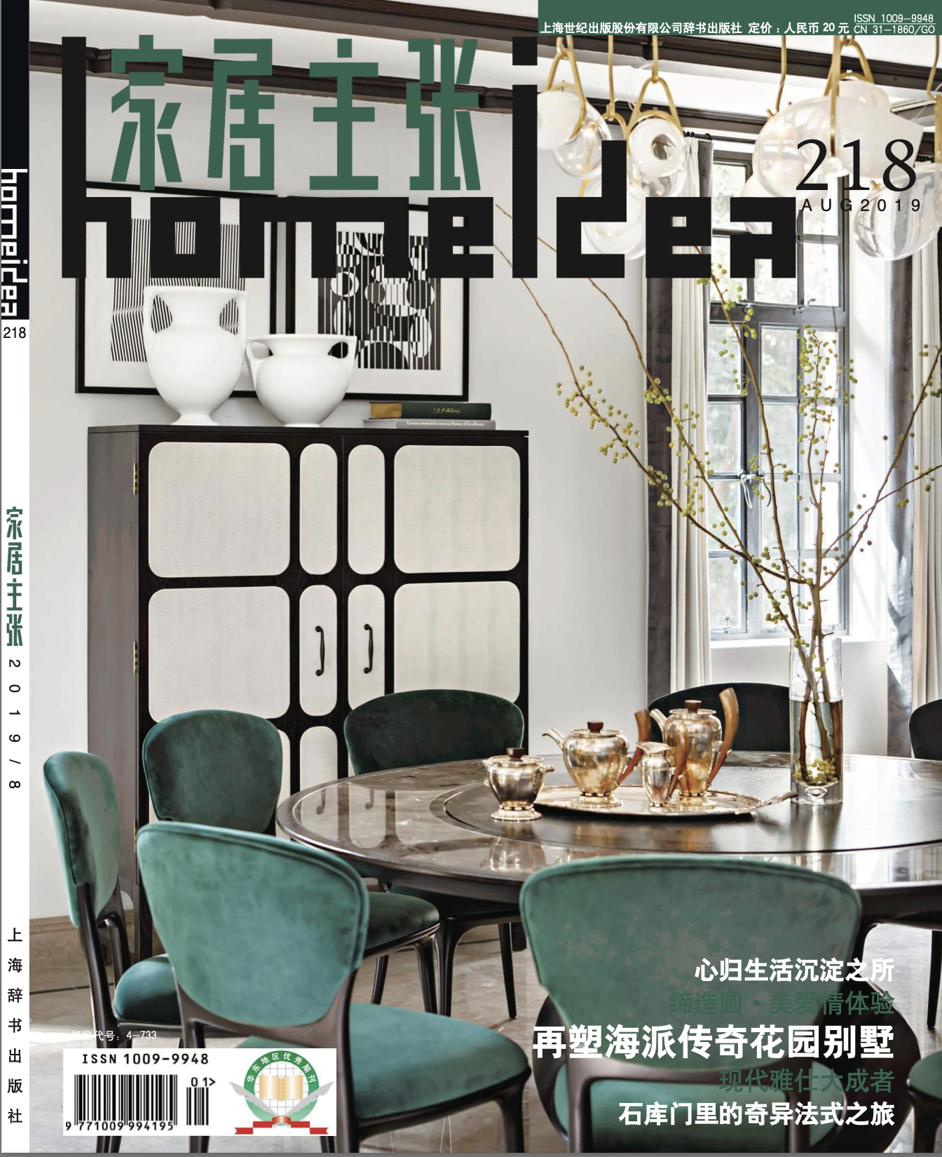 A dining room with a round wooden table surrounded by green upholstered chairs. The table has a decorative tray with gold teapots and cups. Behind, there's a black and white cabinet with white doors, and above it, framed black-and-white artwork. To the right, there's a large window with beige curtains, and a tall glass vase with tree branches with small green leaves. A white pendant light fixture with multiple globe-shaped bulbs hangs from the ceiling.