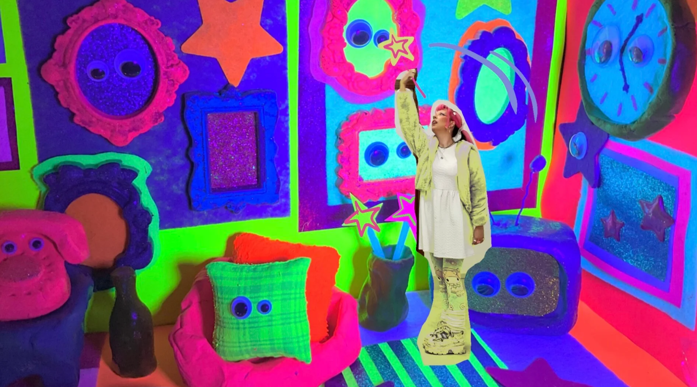 Picture belonging to Naomi Moore -  cutout image of creator standing in middle of bright and neon handmade diorama.