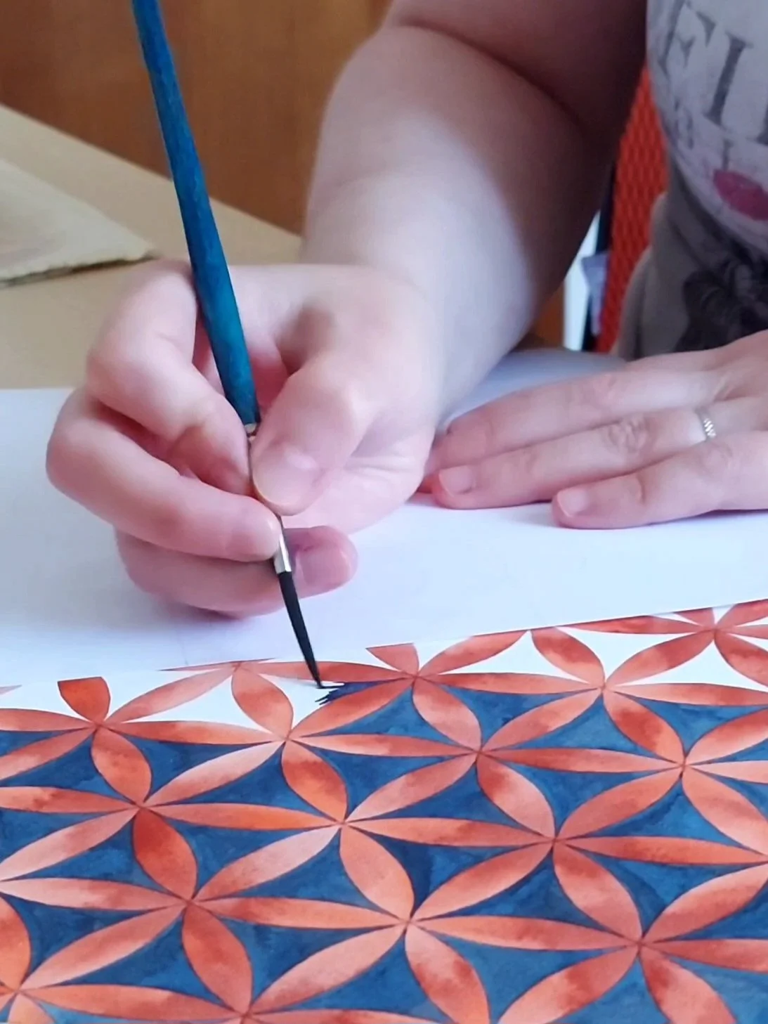 Photo of Joanna Ritchie painting a flower of life pattern with watercolour.
