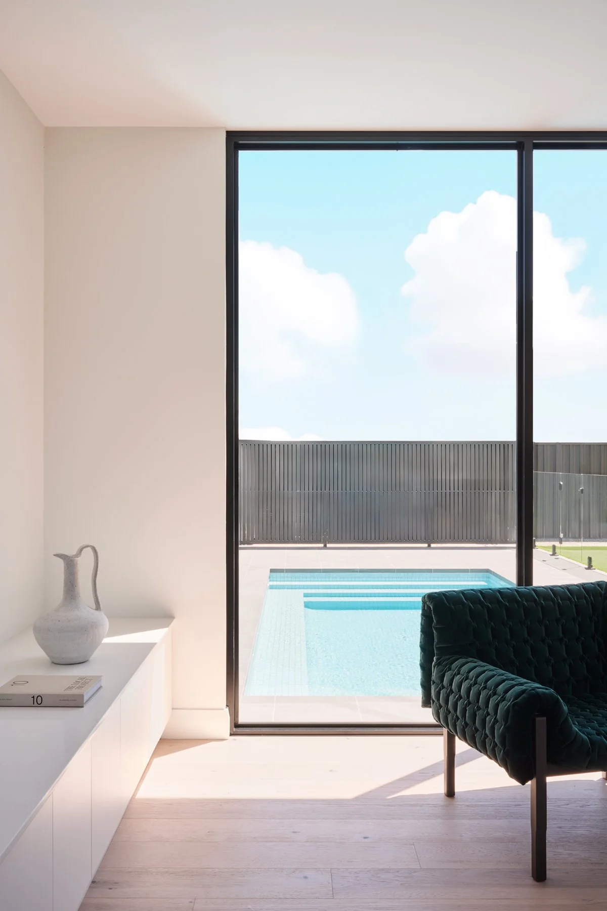 Full-height living room window overlooking the Hazelwood Park swimming pool