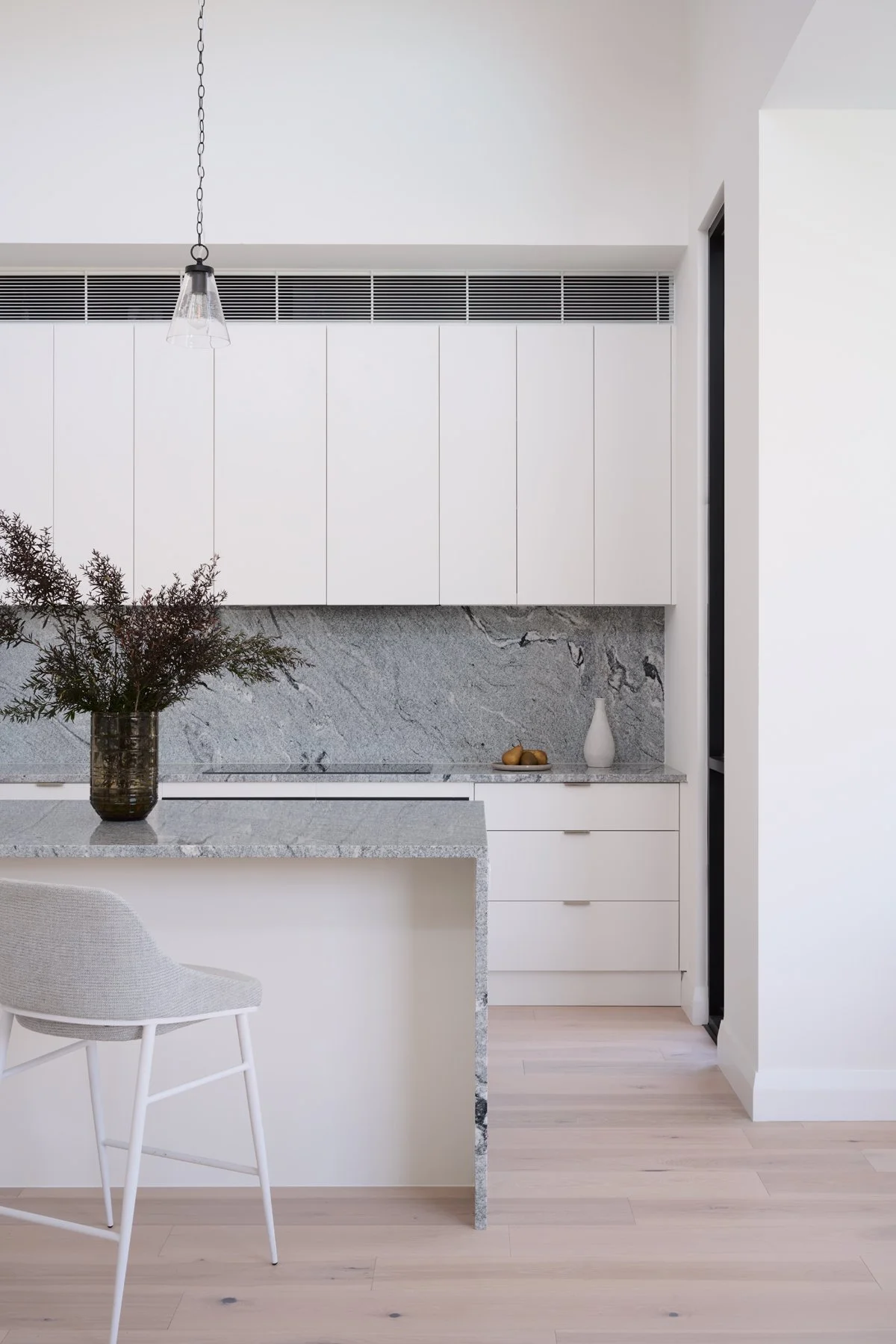 Hazelwood Park kitchen with white cabinetry and a natural stone island and splashback