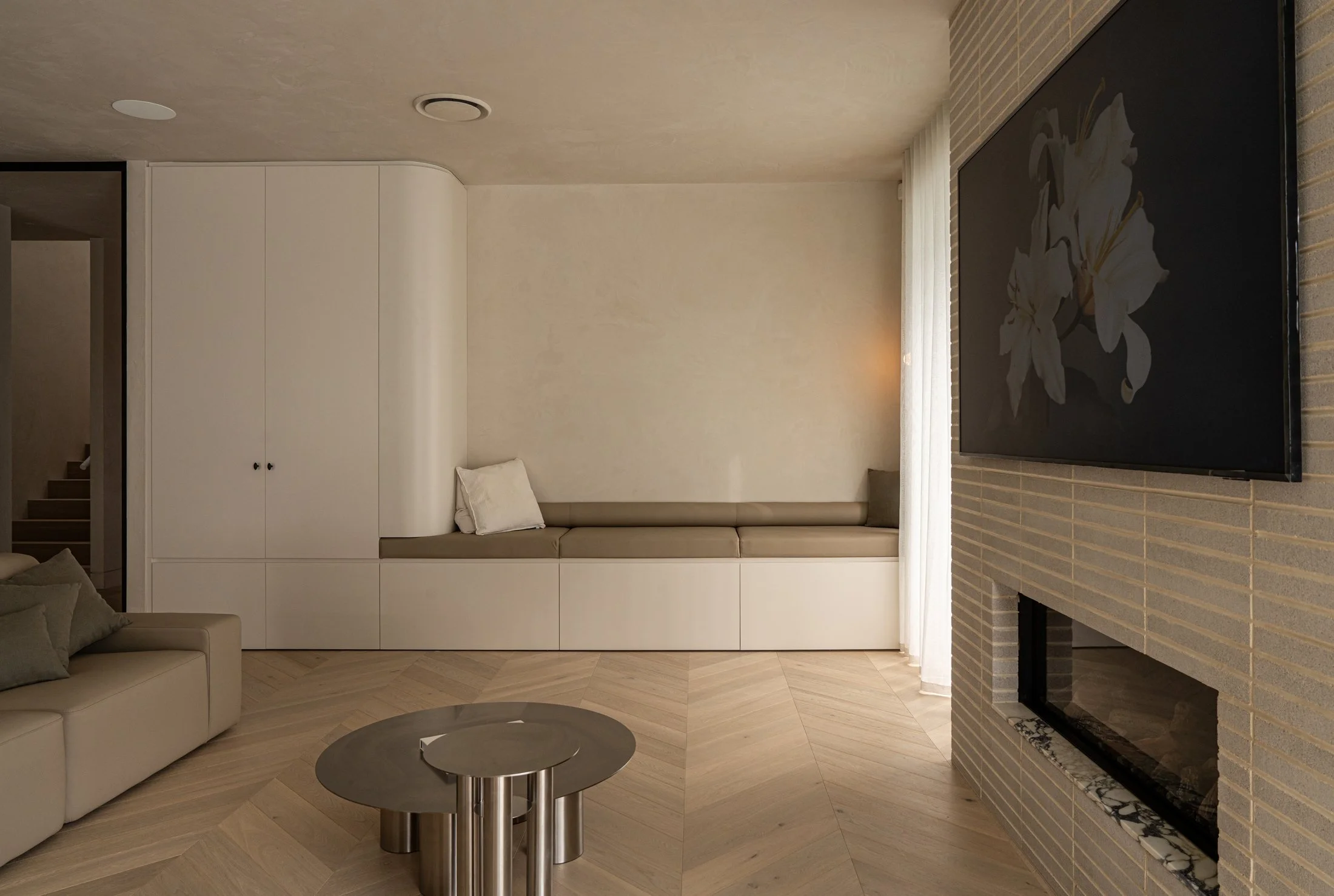 Pale built-in cabinetry and a brick fireplace in the St Morris living room