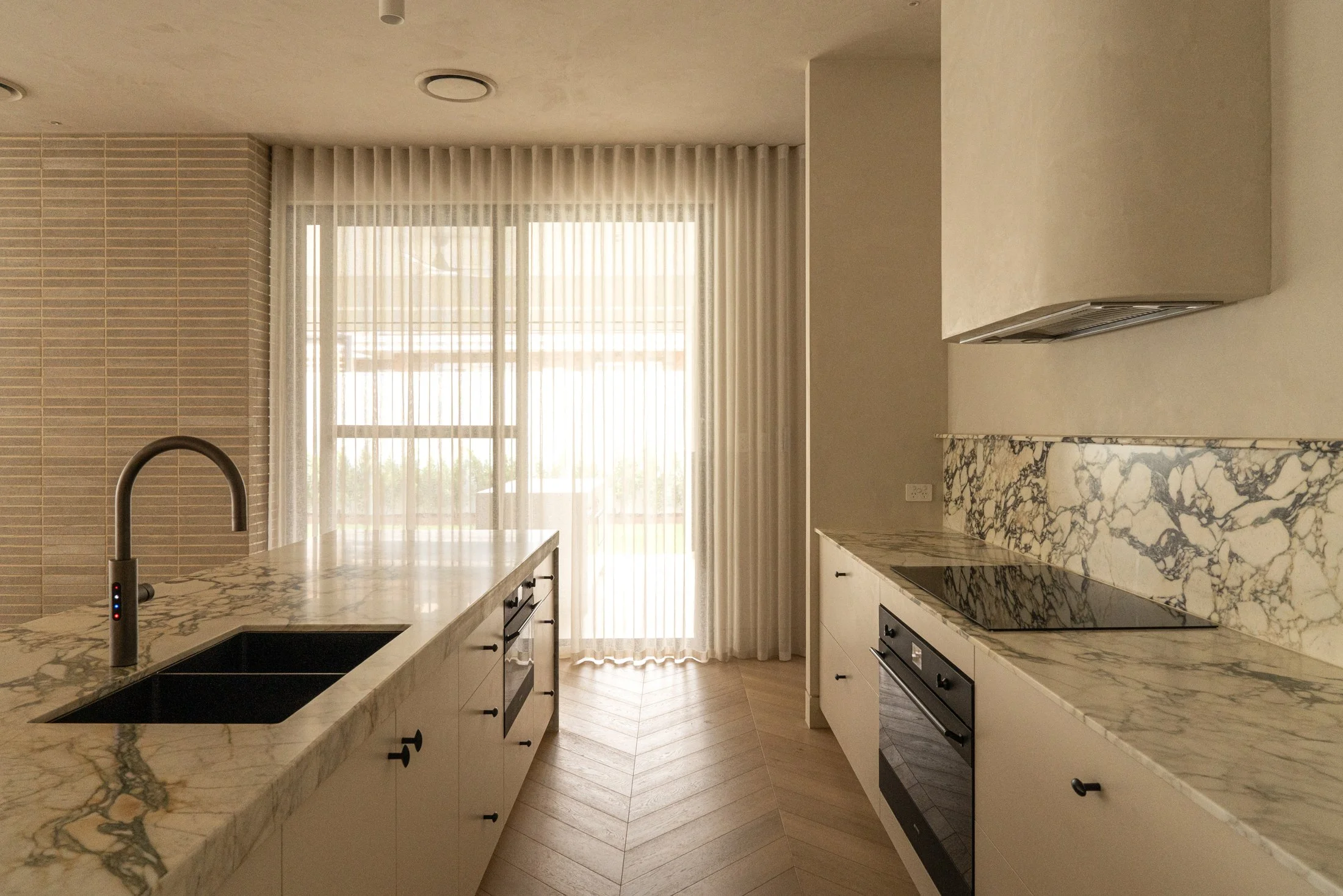 View along the St Morris kitchen island towards full-height curtains