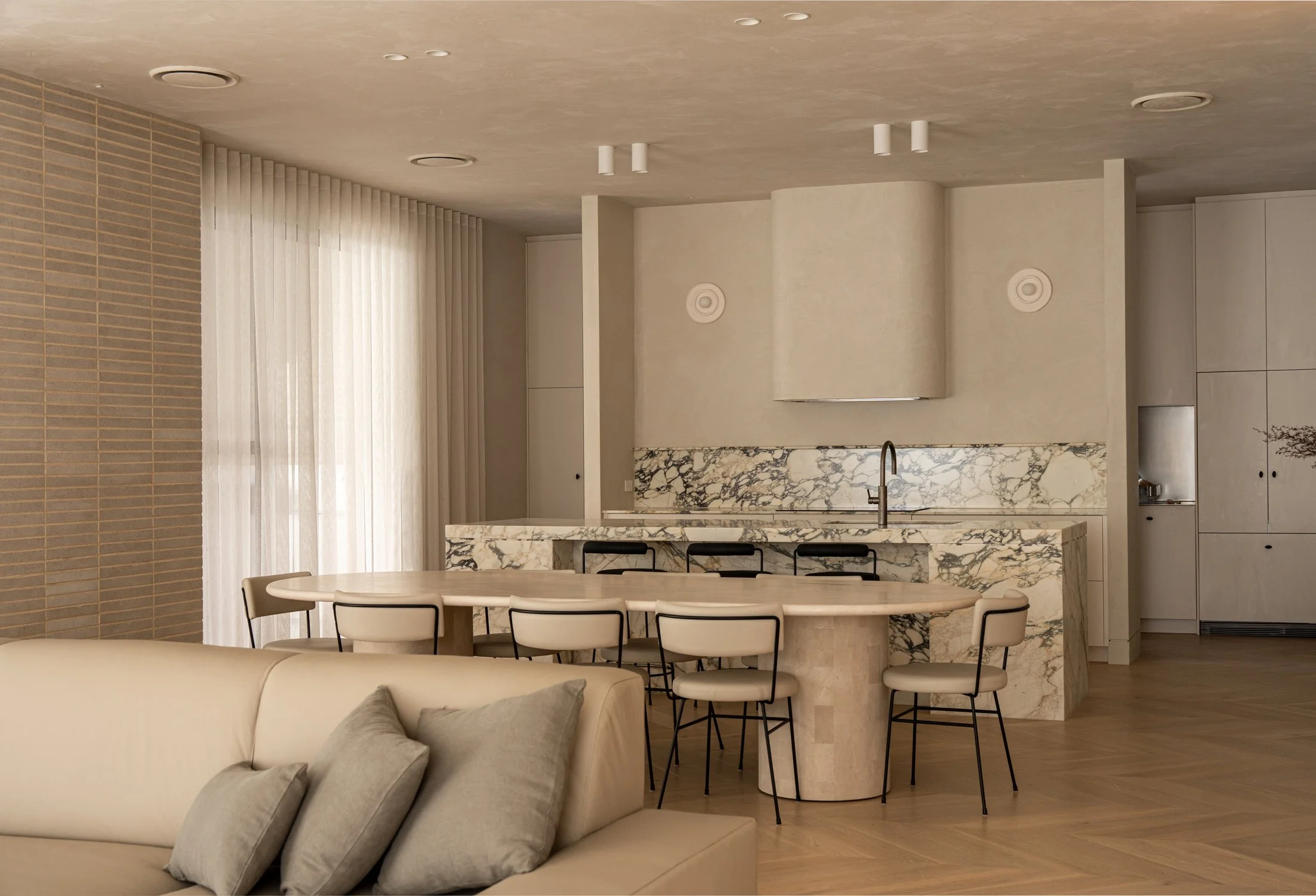 Dining table beside the veined stone kitchen island in St Morris