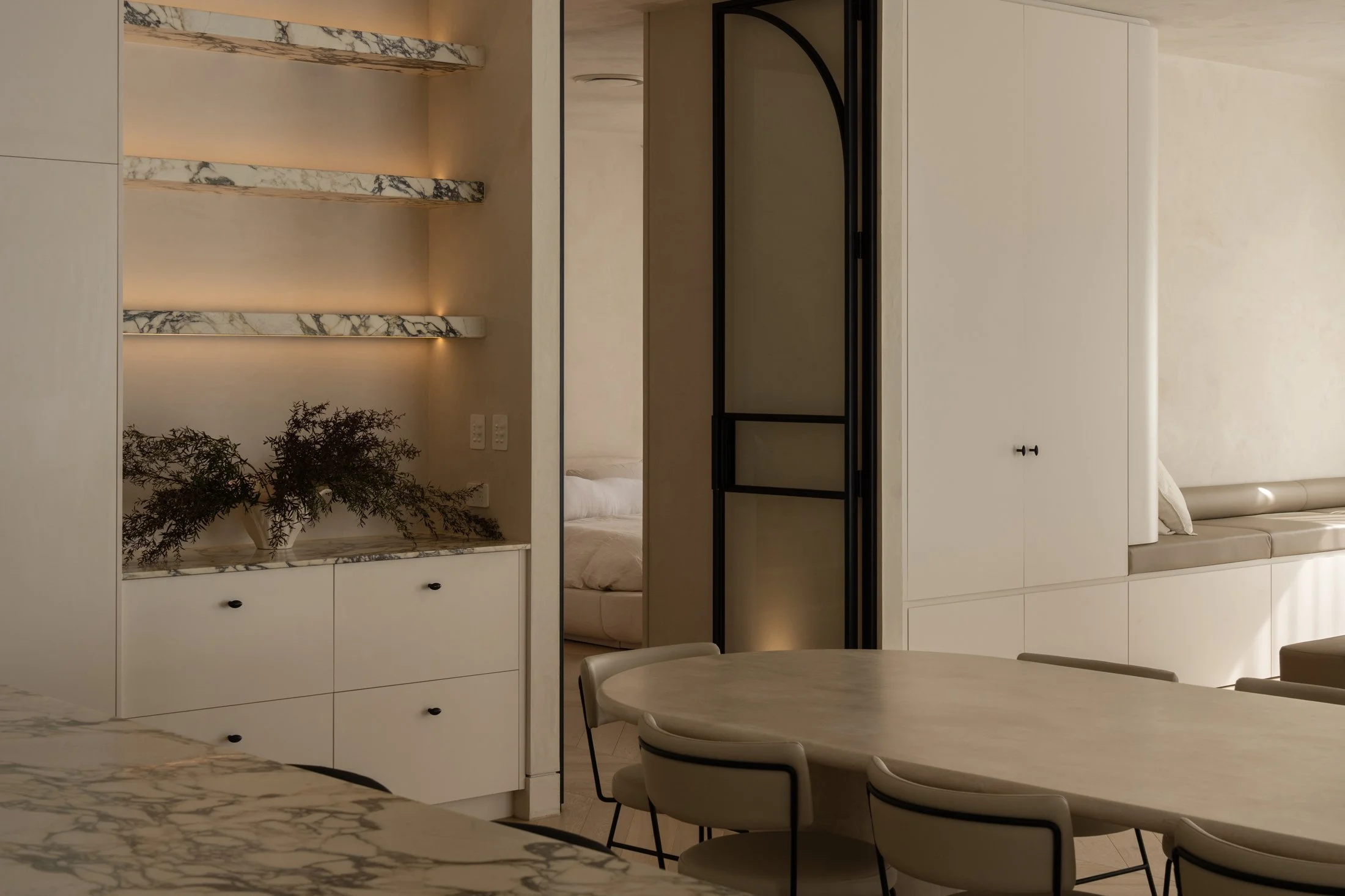 Glass display shelving and an arched doorway in the St Morris home