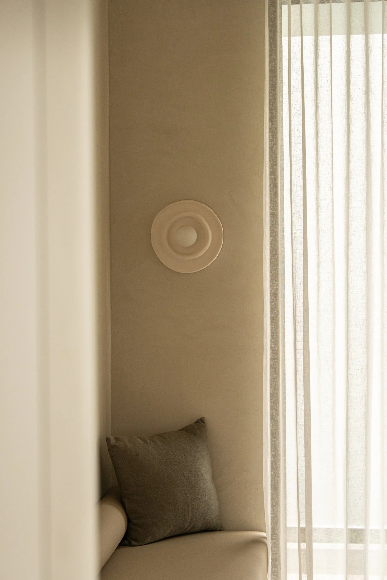 Decorative wall detail beside sheer curtains in St Morris