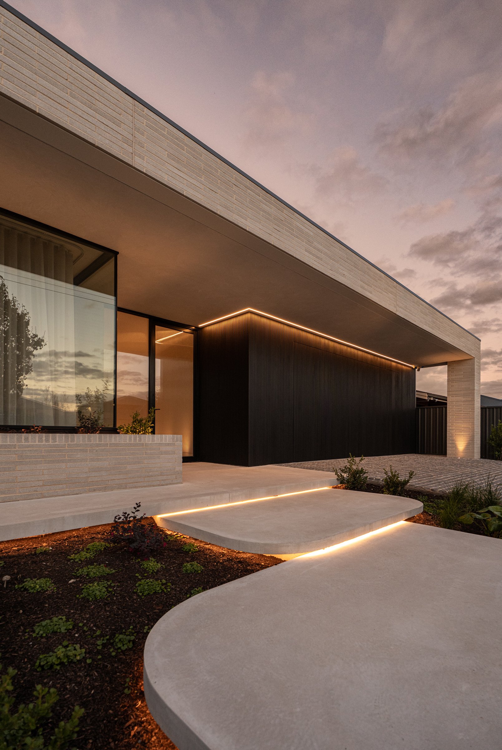 St Morris entry at dusk with curved steps and warm exterior lighting