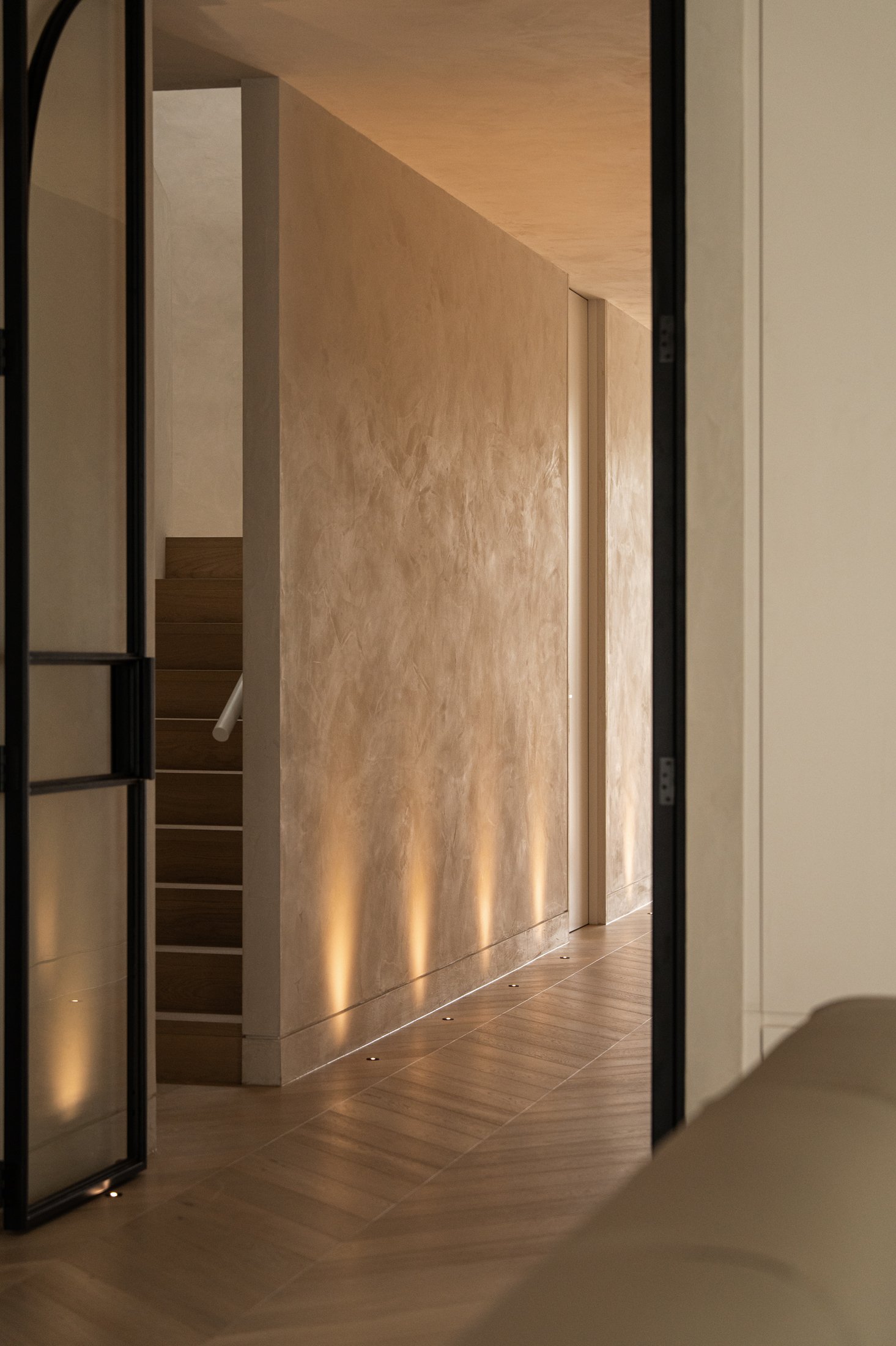 Textured plaster hallway wall lit by warm sunlight in St Morris