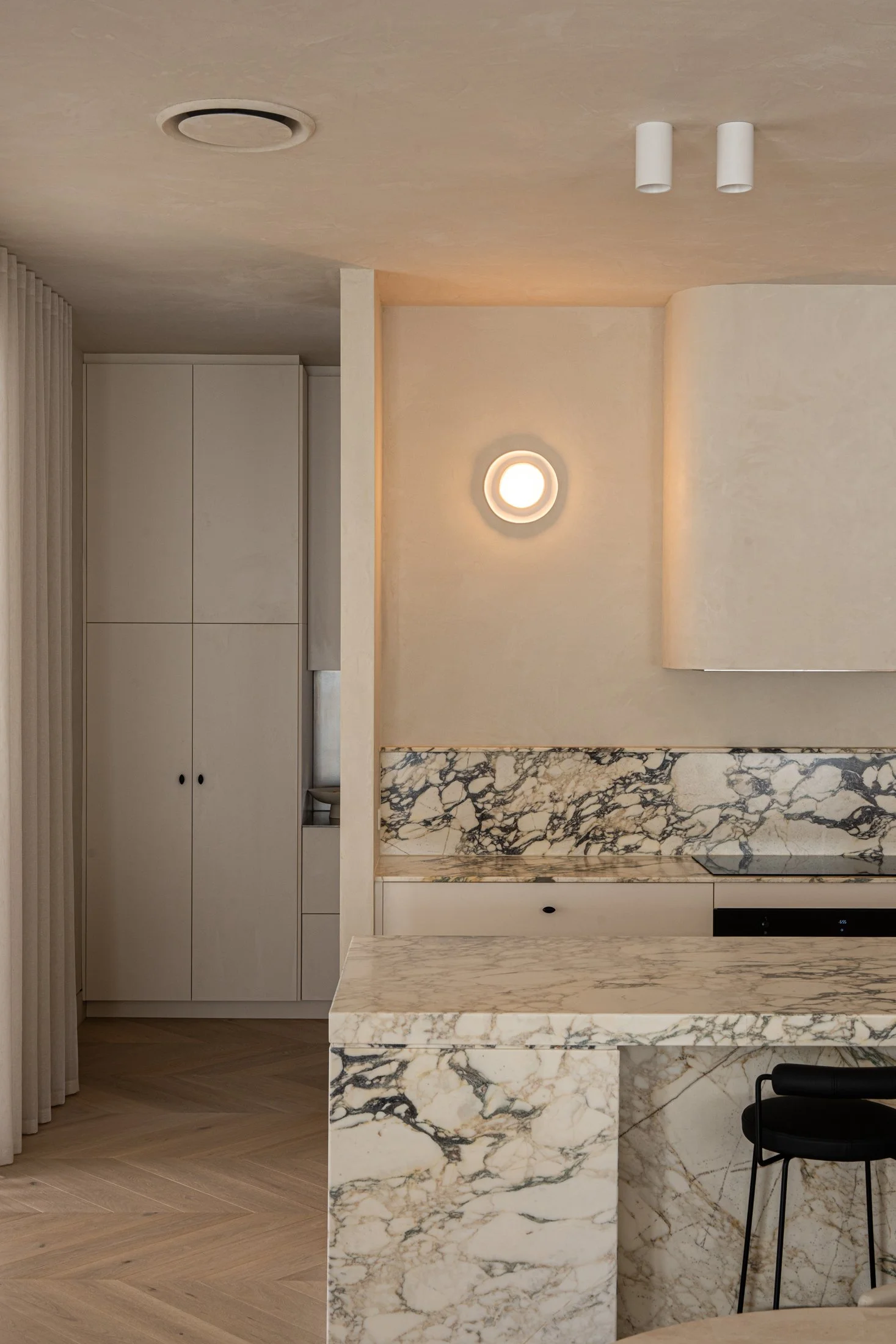 Kitchen stone splashback and decorative wall light beside a concealed door in St Morris