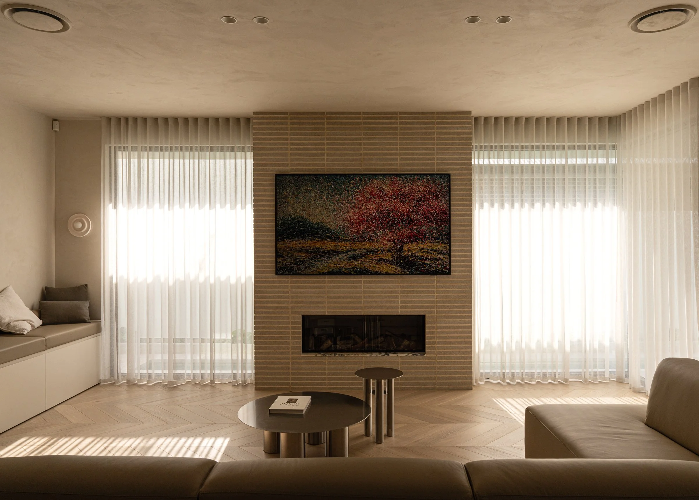St Morris living room with fireplace artwork and full-height sheer curtains