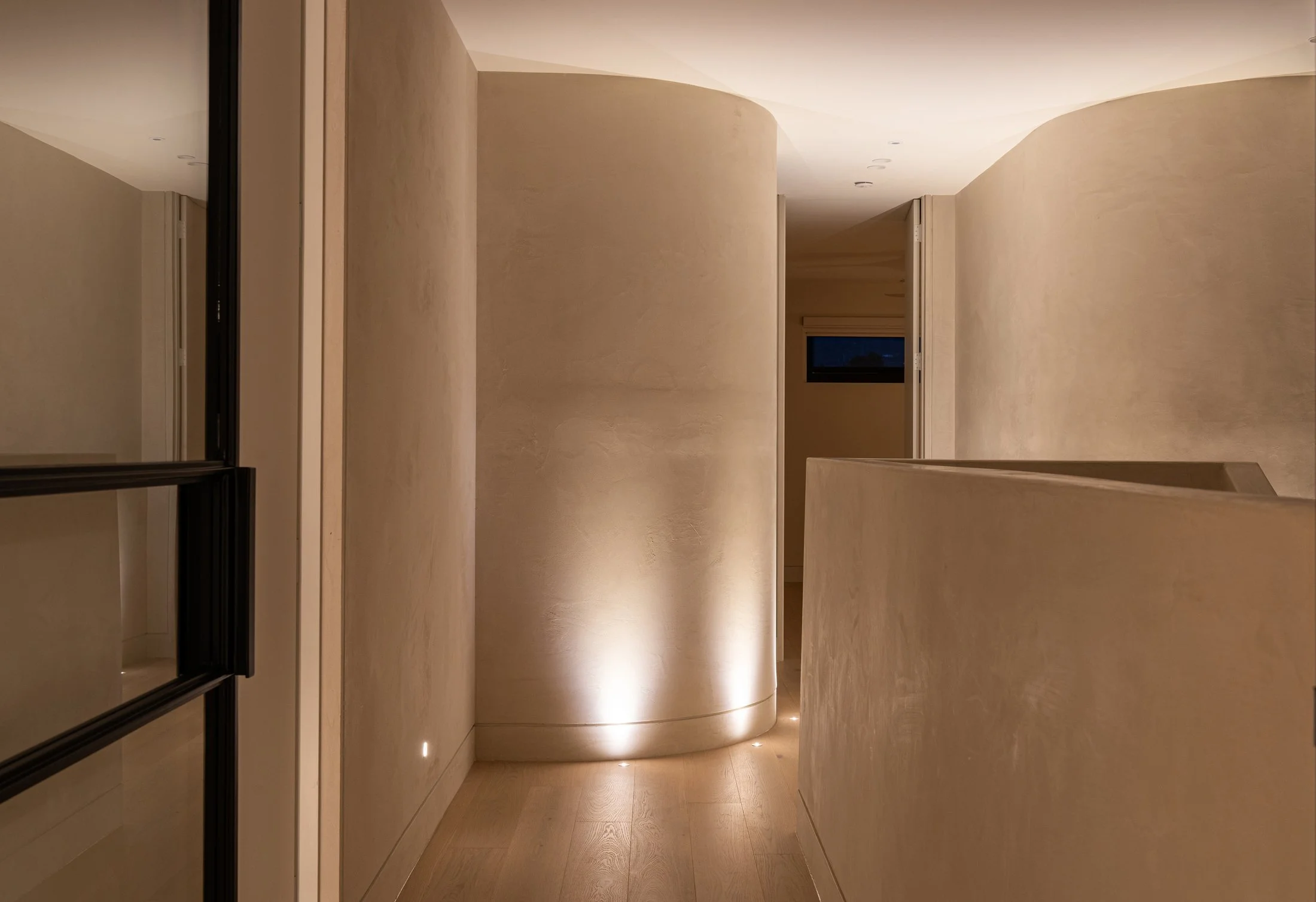 Curved plaster walls and low-level lighting in the St Morris hallway