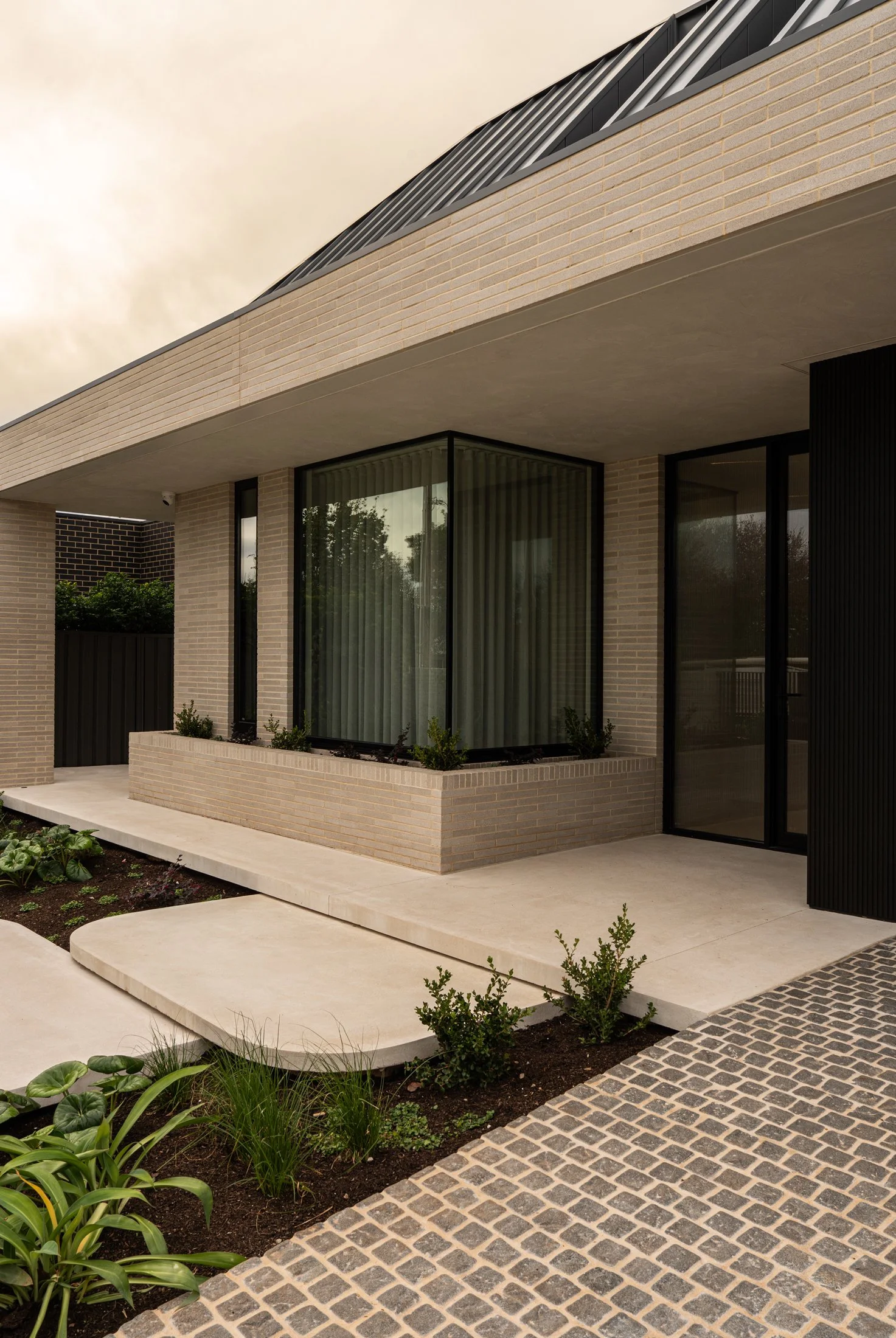 Pale brick exterior and full-height windows at the St Morris home