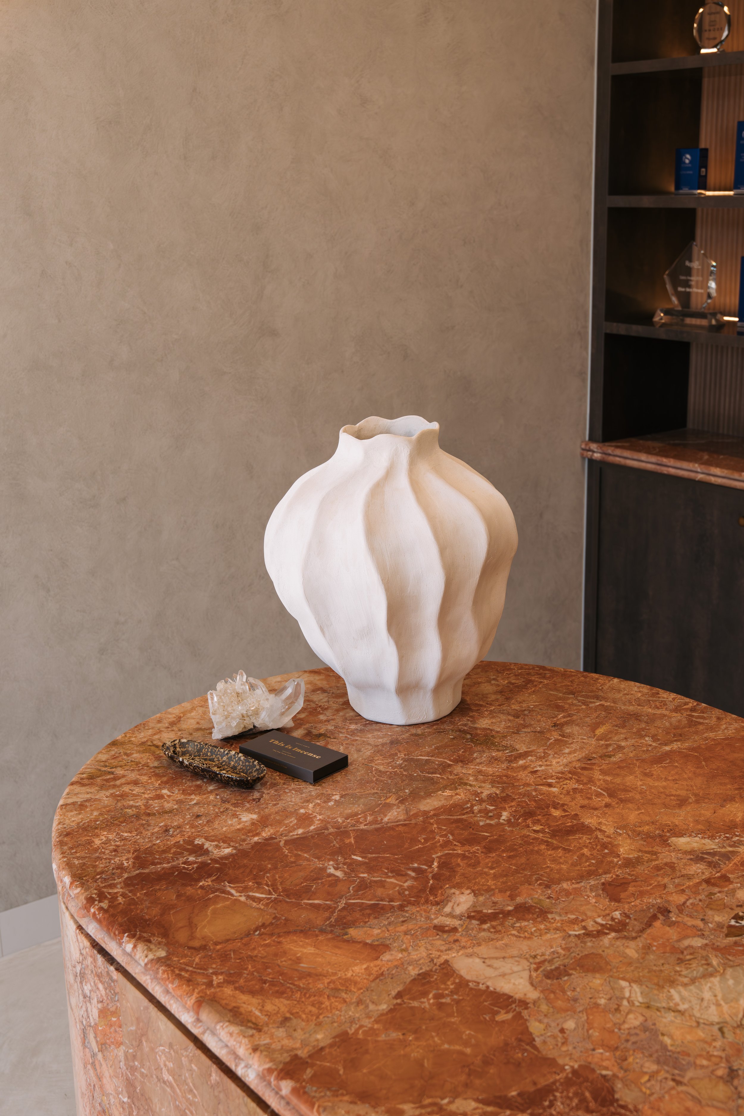 Sculptural white vase on the marble reception counter at Elixir Skin Fitness