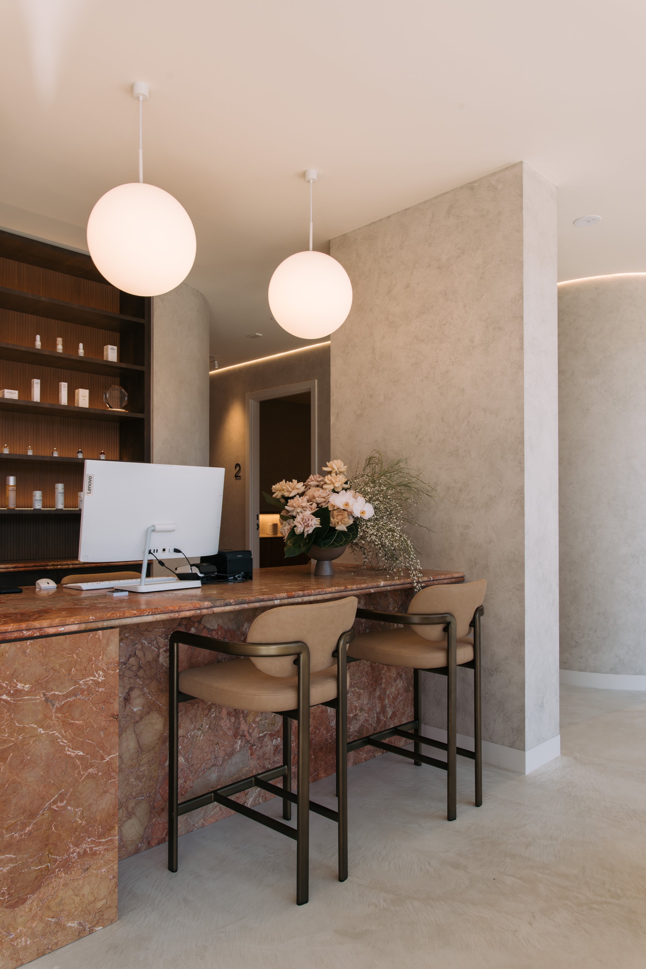 Elixir Skin Fitness reception desk beneath round pendant lights