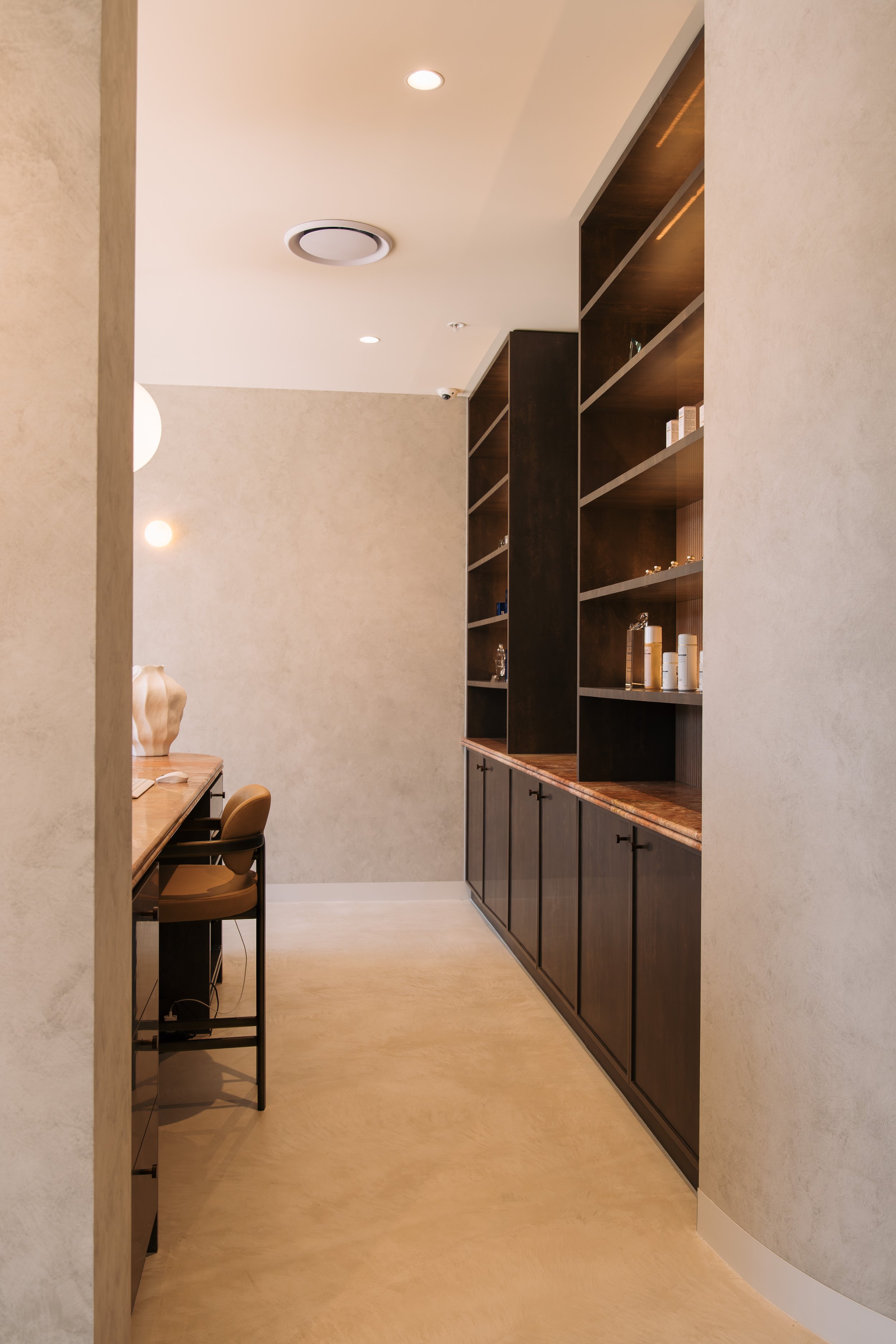 Dark timber display shelves and lower cabinetry at Elixir Skin Fitness