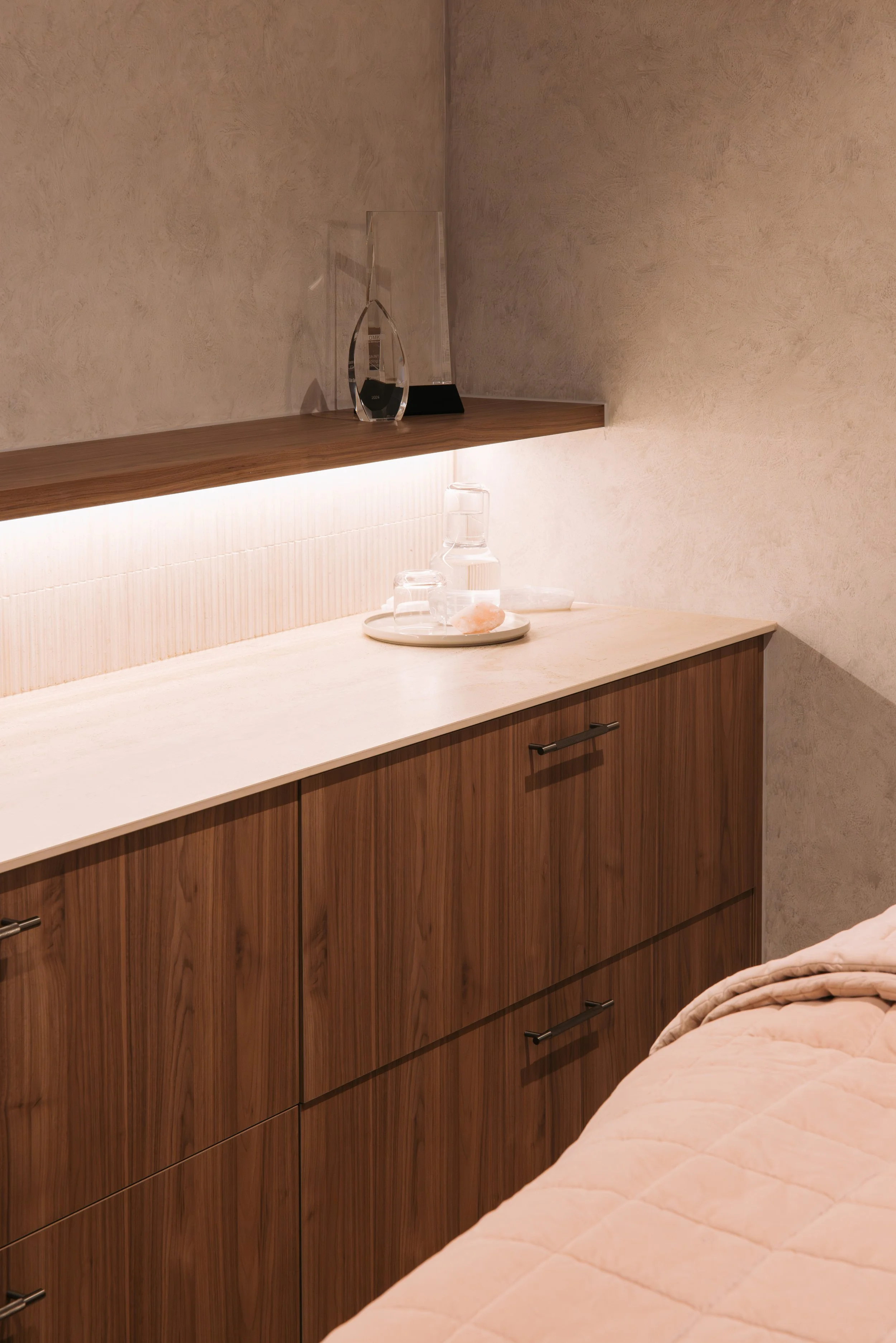 Timber cabinetry and a pale stone countertop in an Elixir Skin Fitness treatment room in Norwood
