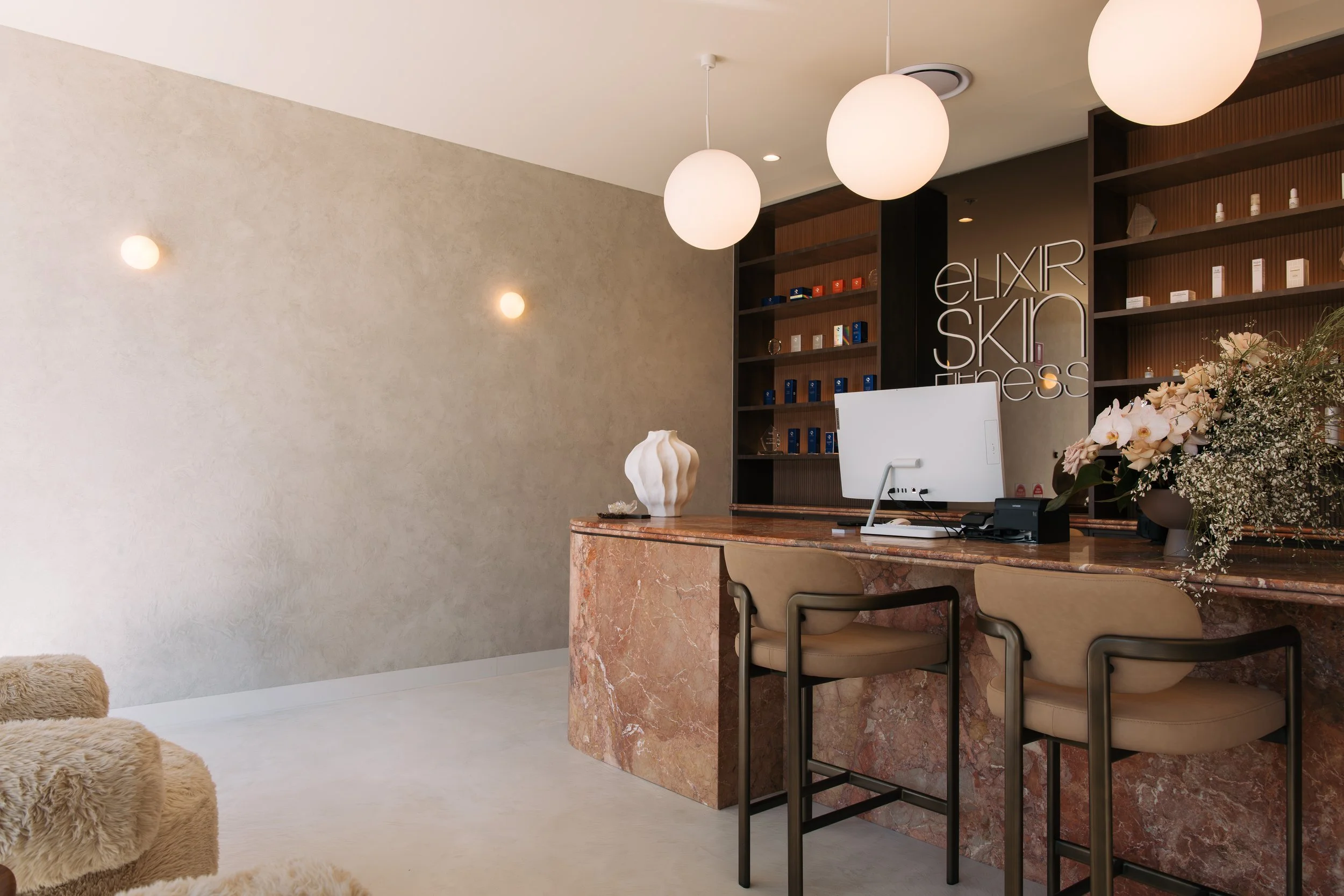 Norwood clinic reception with globe pendant lighting and a curved stone desk