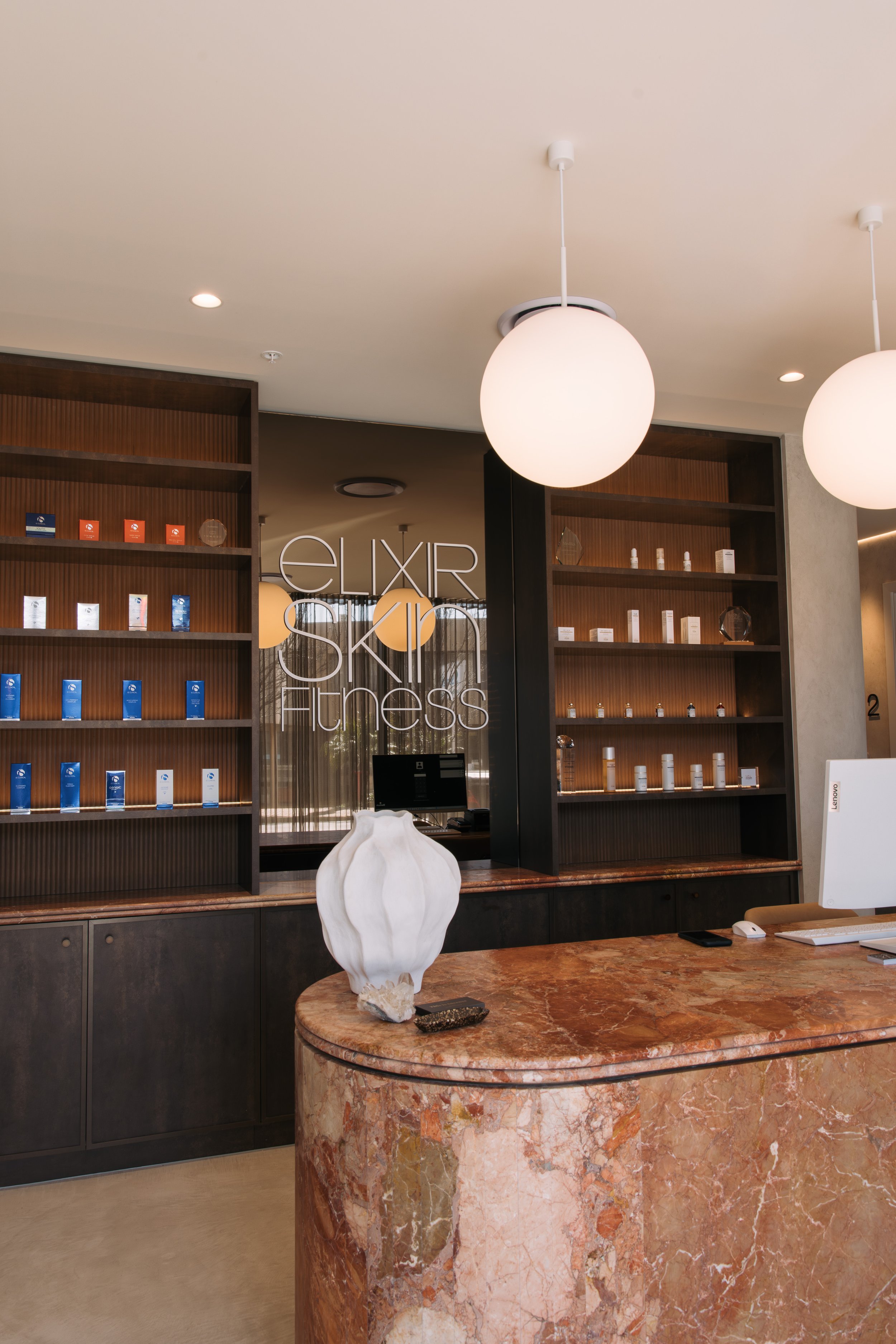 Marble reception counter and product display shelving at Elixir Skin Fitness