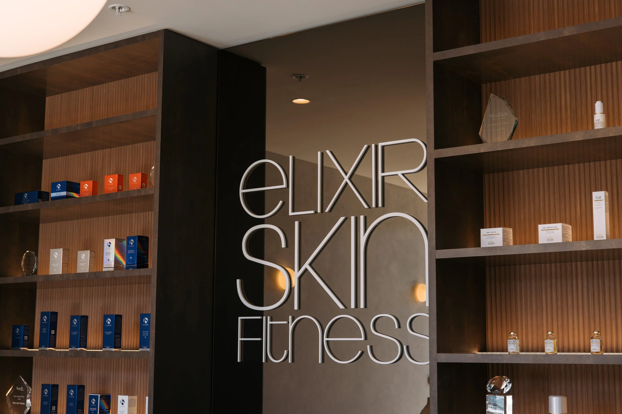 Elixir Skin Fitness lettering between timber product shelves in Norwood