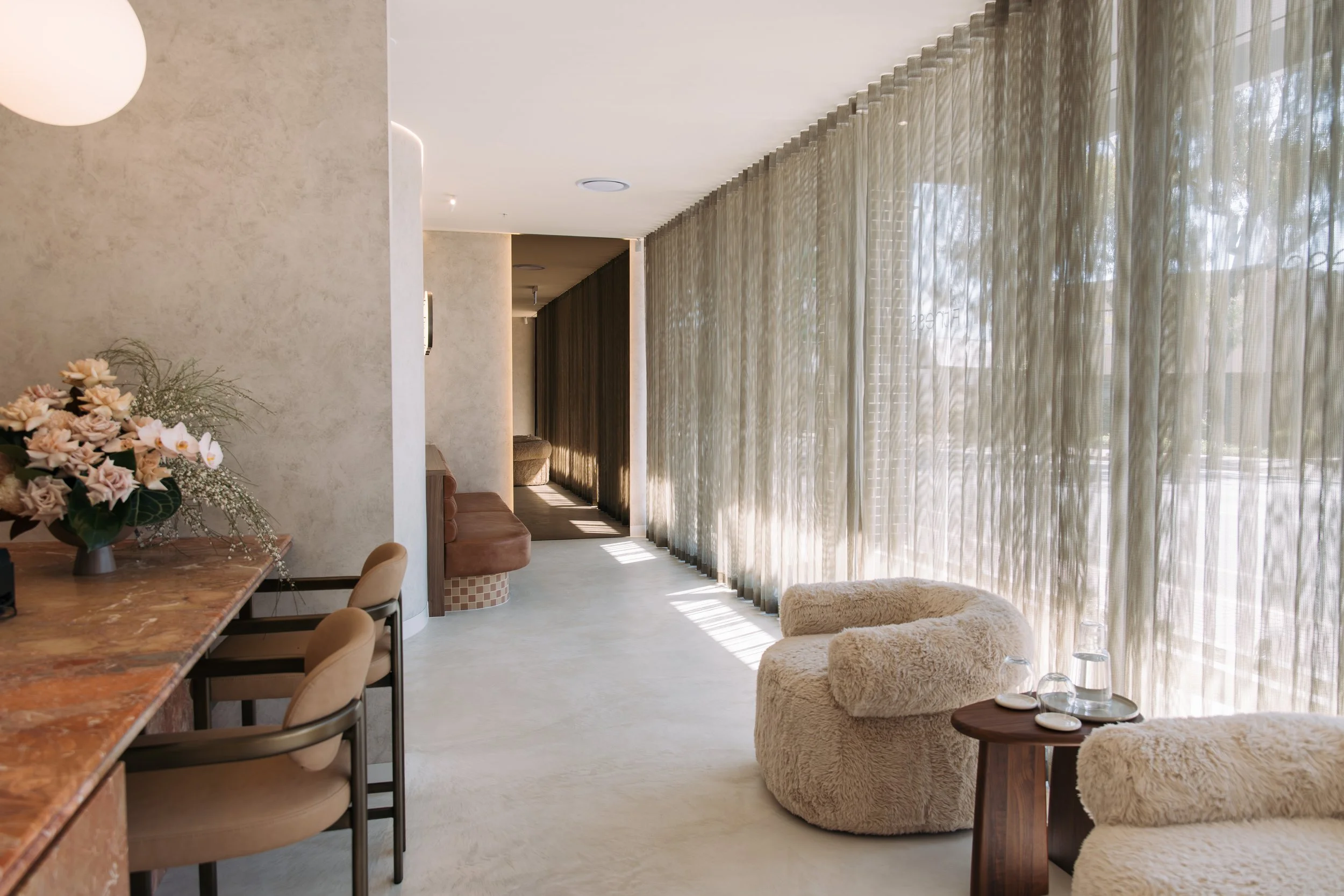 Long sheer-curtained window and textured seating in the Elixir Skin Fitness waiting area