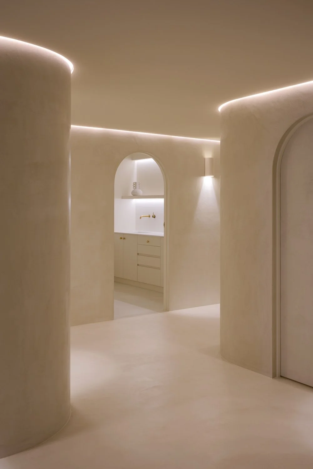 Curved plaster walls, recessed lighting and an arched vanity niche at Sculpt Skin Clinic in Stepney