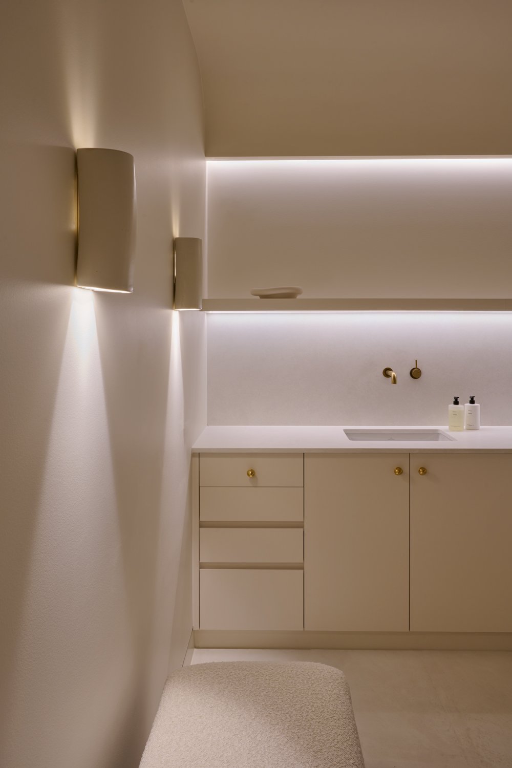 Pale treatment-room cabinetry, basin and recessed shelf lighting at Sculpt Skin Clinic