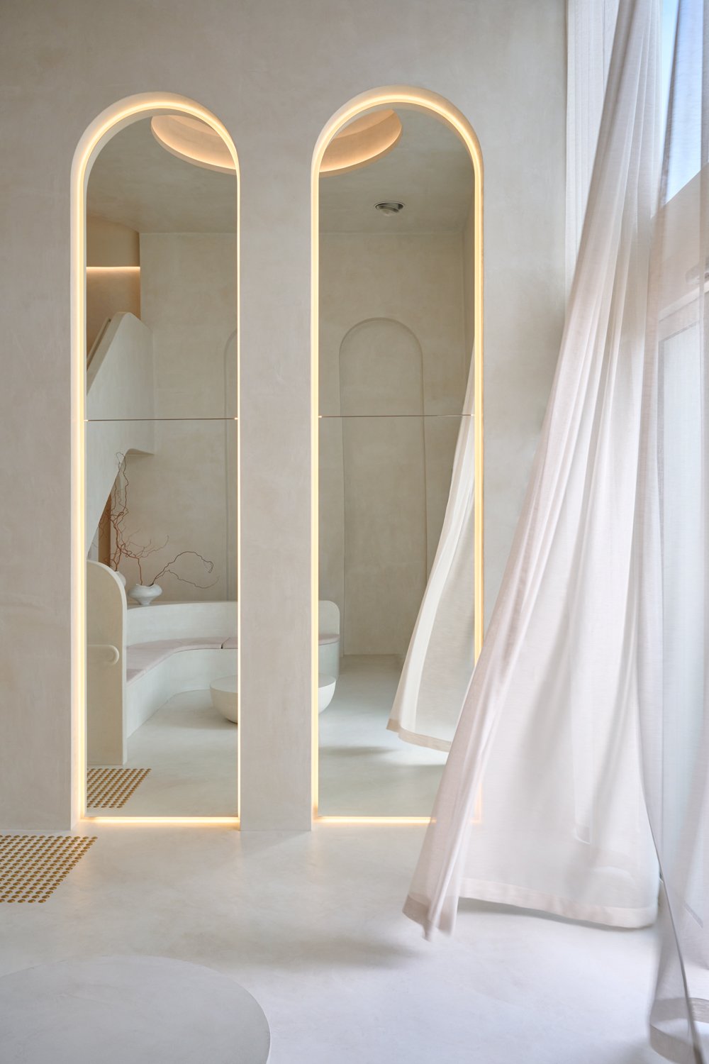 Illuminated arched mirrors and sheer curtains at Sculpt Skin Clinic